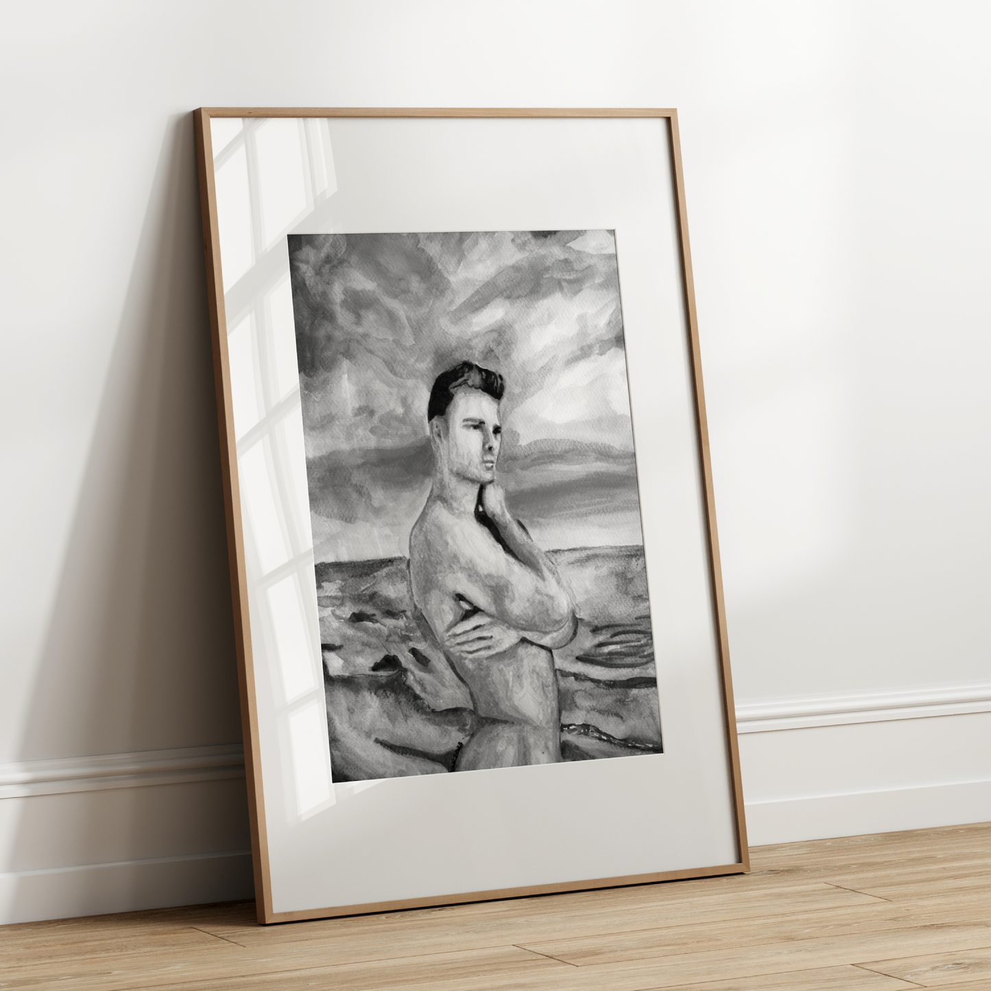 Framed black and white portrait leaning against a white wall.