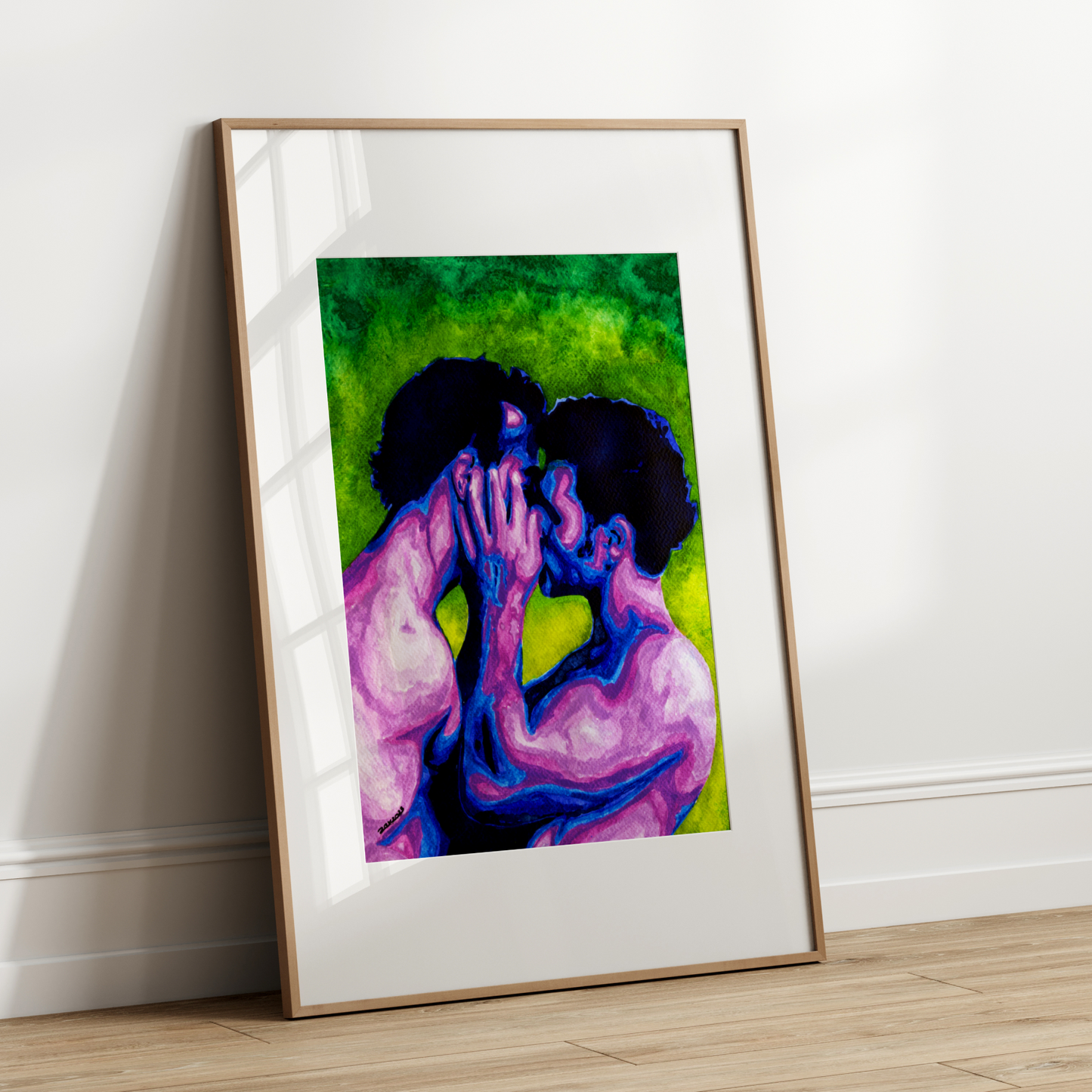 Framed artwork of two people embracing on a white wall.
