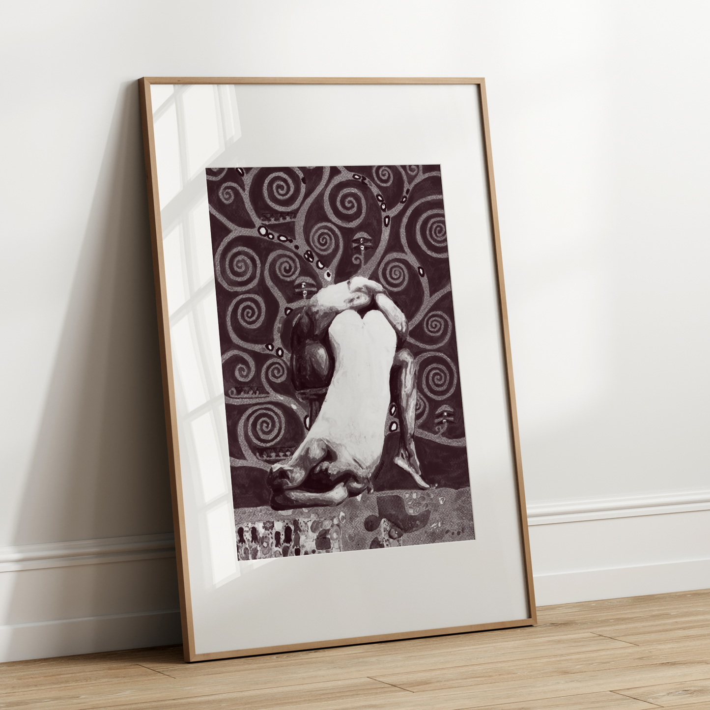 Framed artwork leaning against a white wall on a wooden floor
