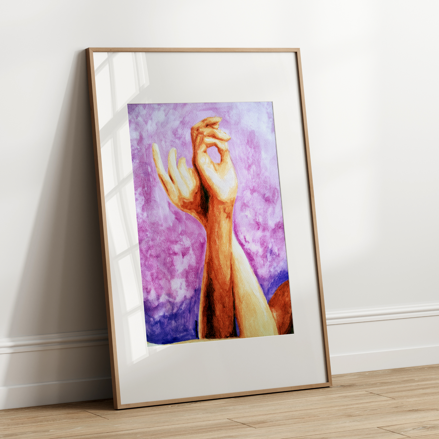Framed artwork of a hand on a white wall