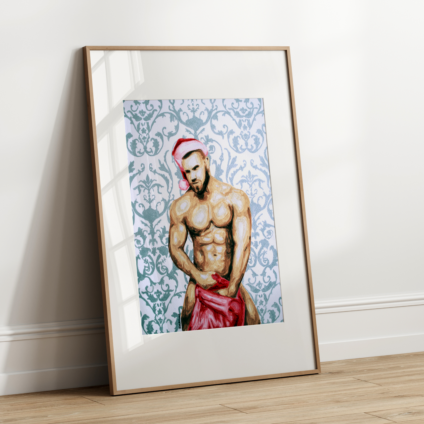 Framed artwork of a shirtless man with a red garment on a white wall.