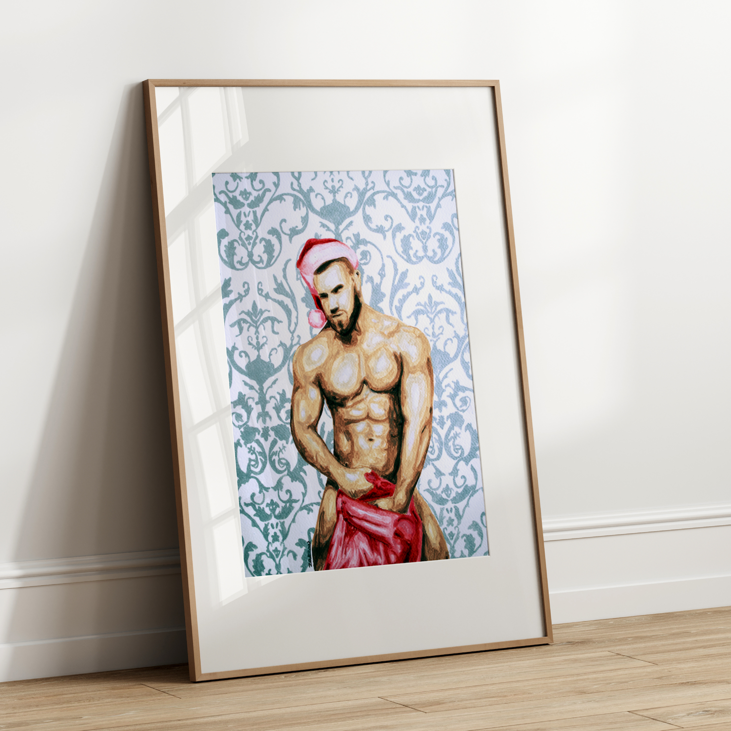 Framed artwork of a shirtless man with a red garment on a white wall.