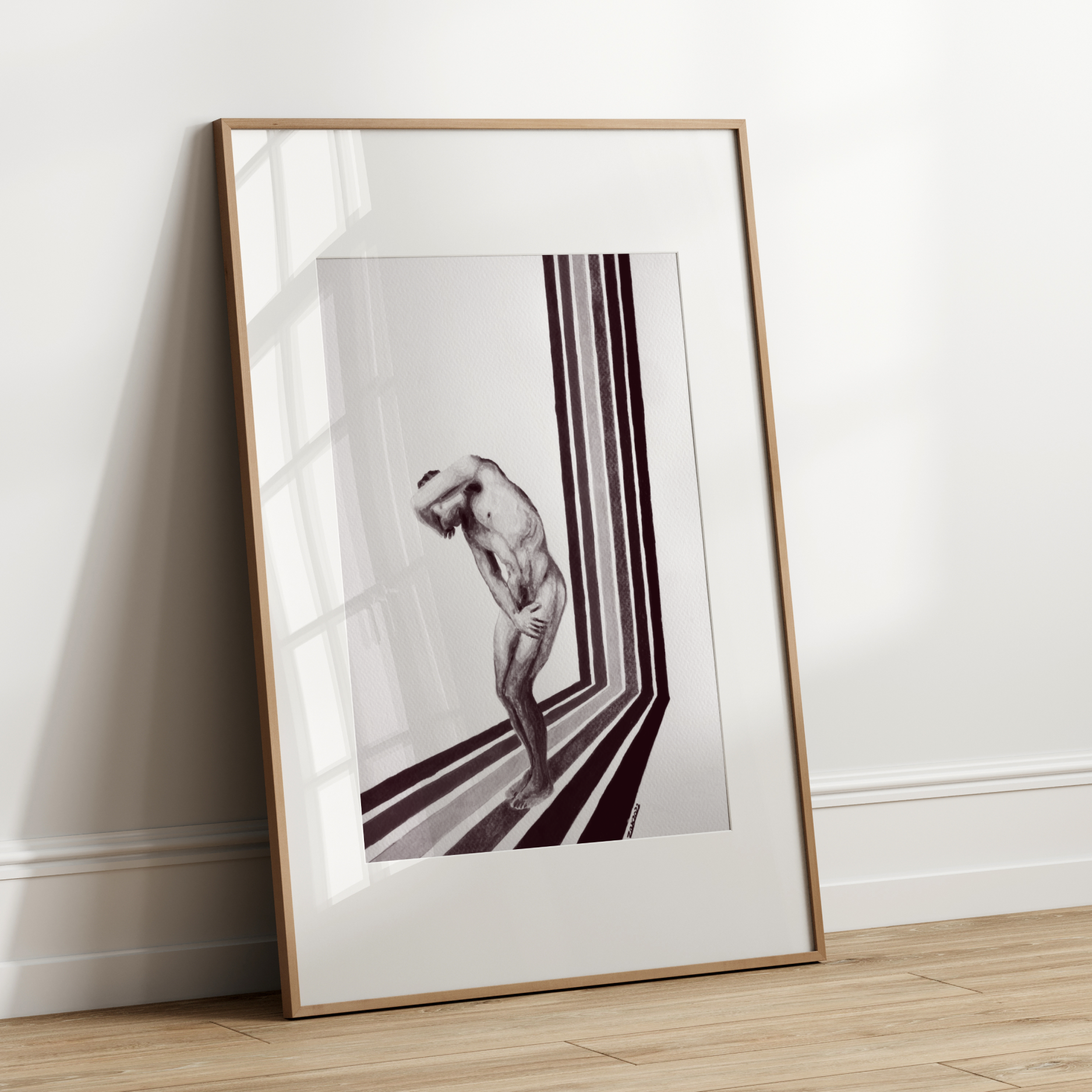 Framed black and white artwork leaning against a white wall.