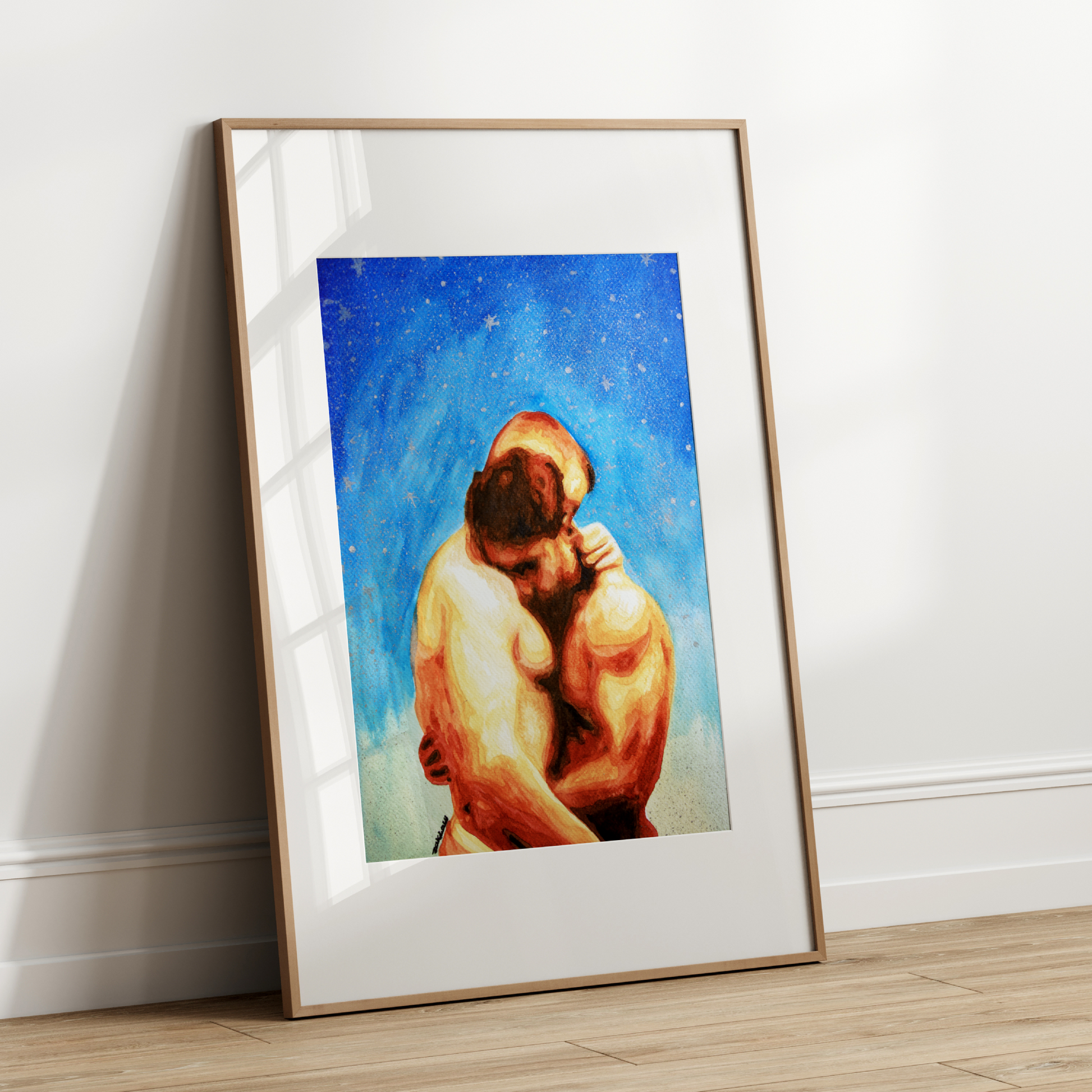 Framed artwork of two people embracing against a blue sky with stars on a white wall.