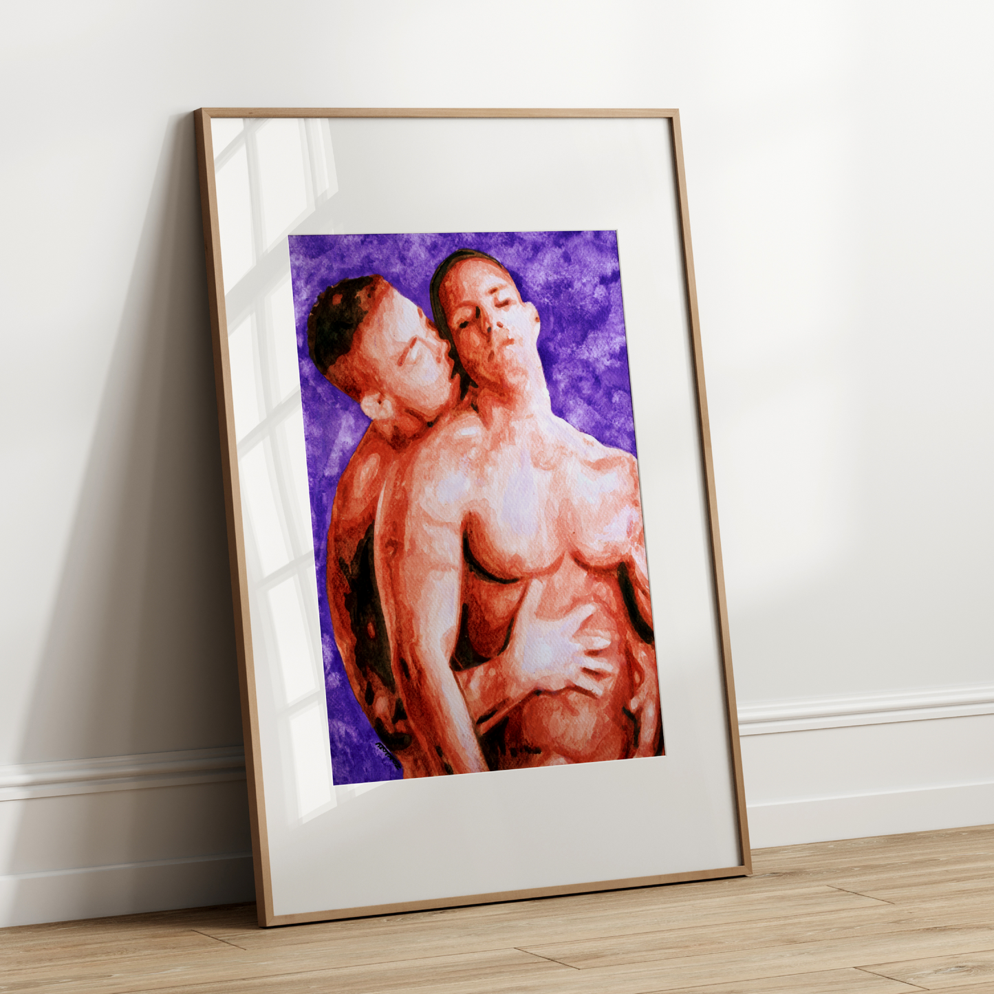 Framed artwork of two nude figures on a white wall