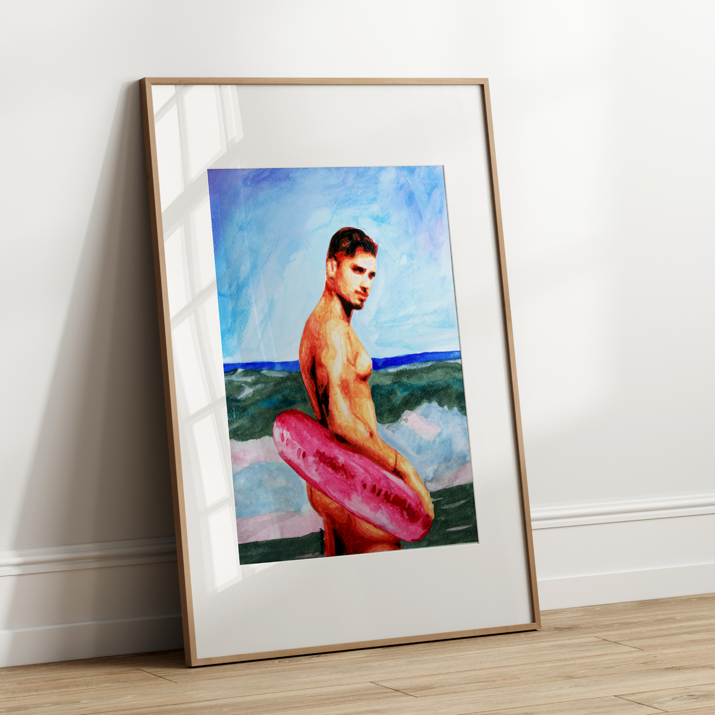 Framed artwork of a man with a pink inner tube against a beach scene.