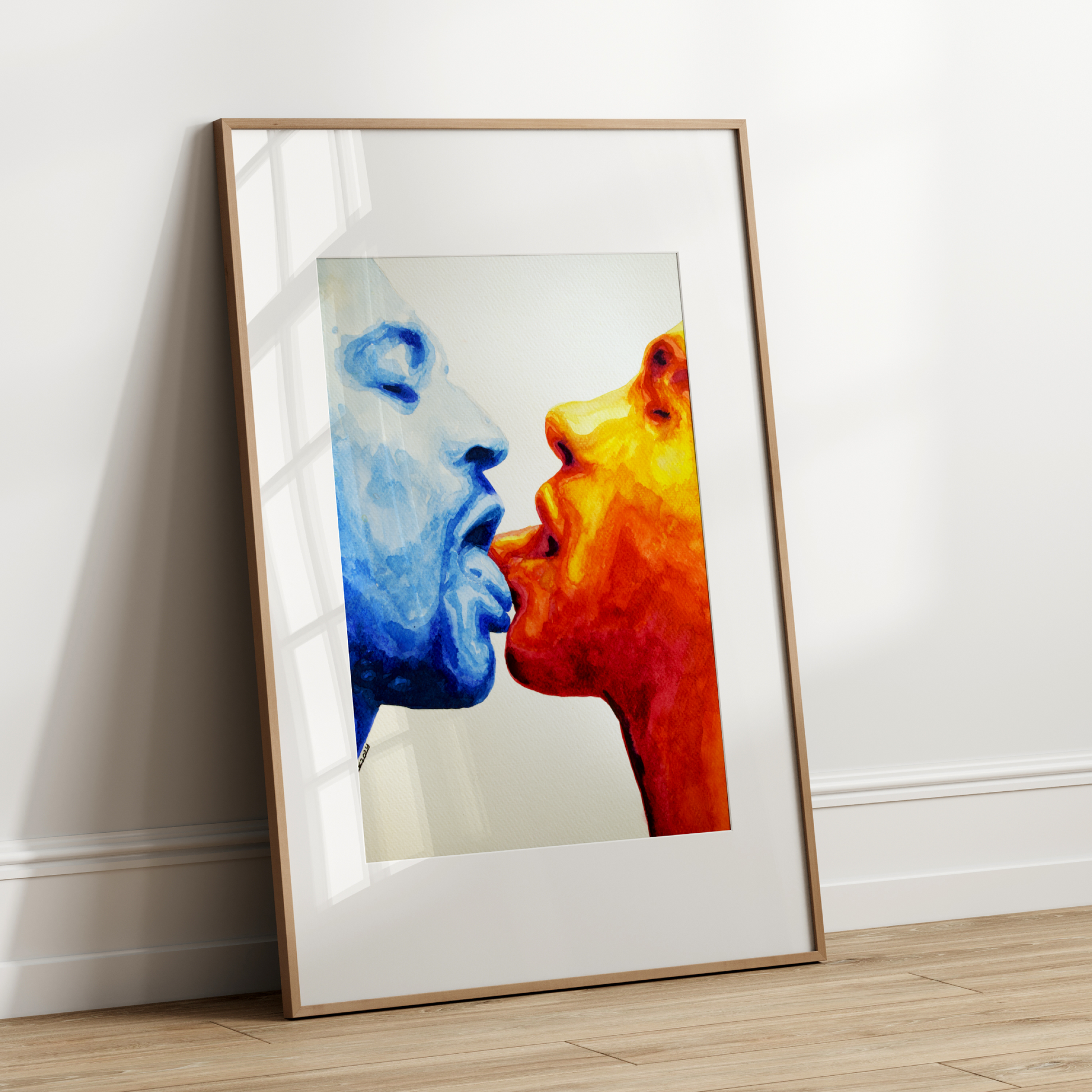 Framed artwork of two faces, one blue and one red, against a white wall.