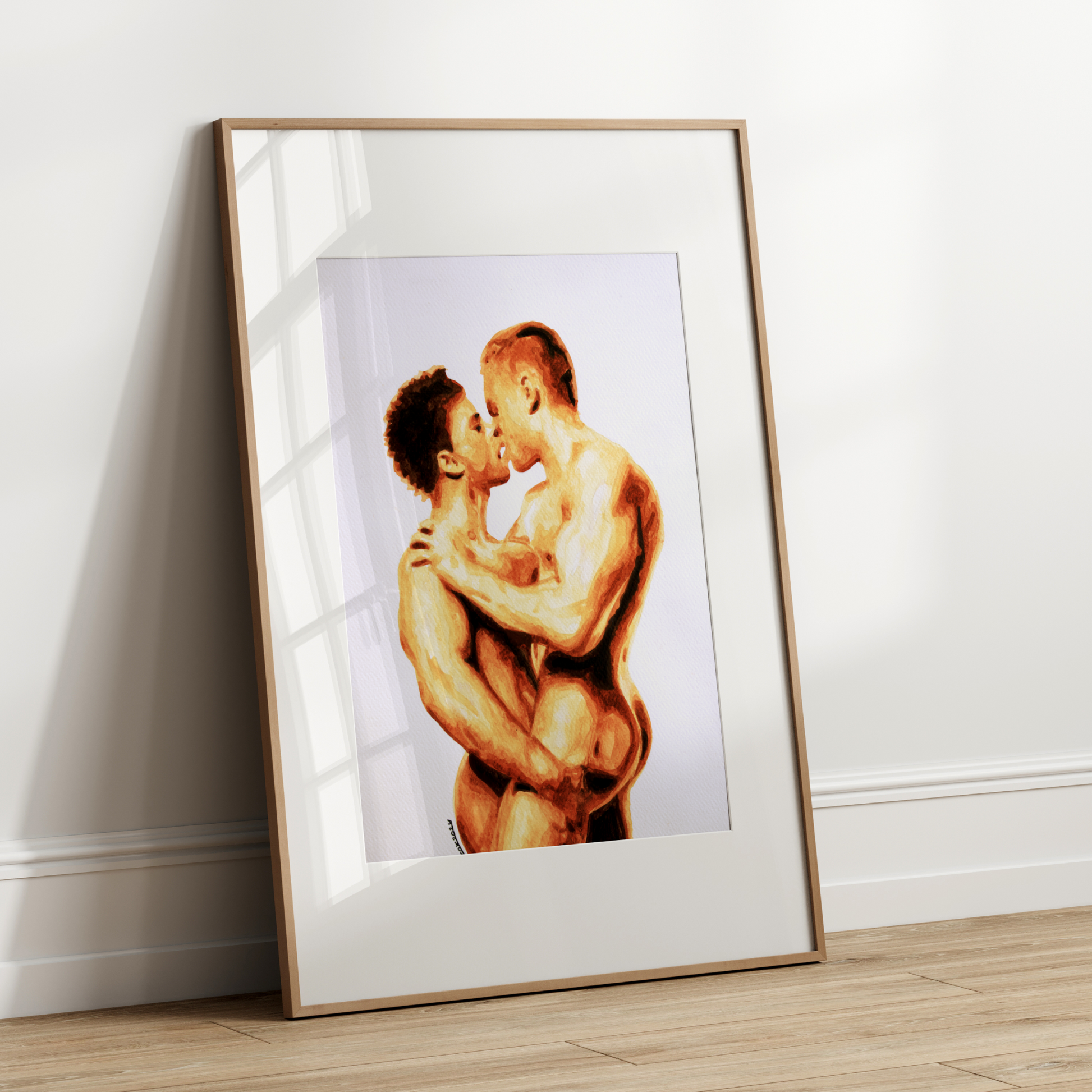 Framed artwork of two nude figures embracing on a white wall.
