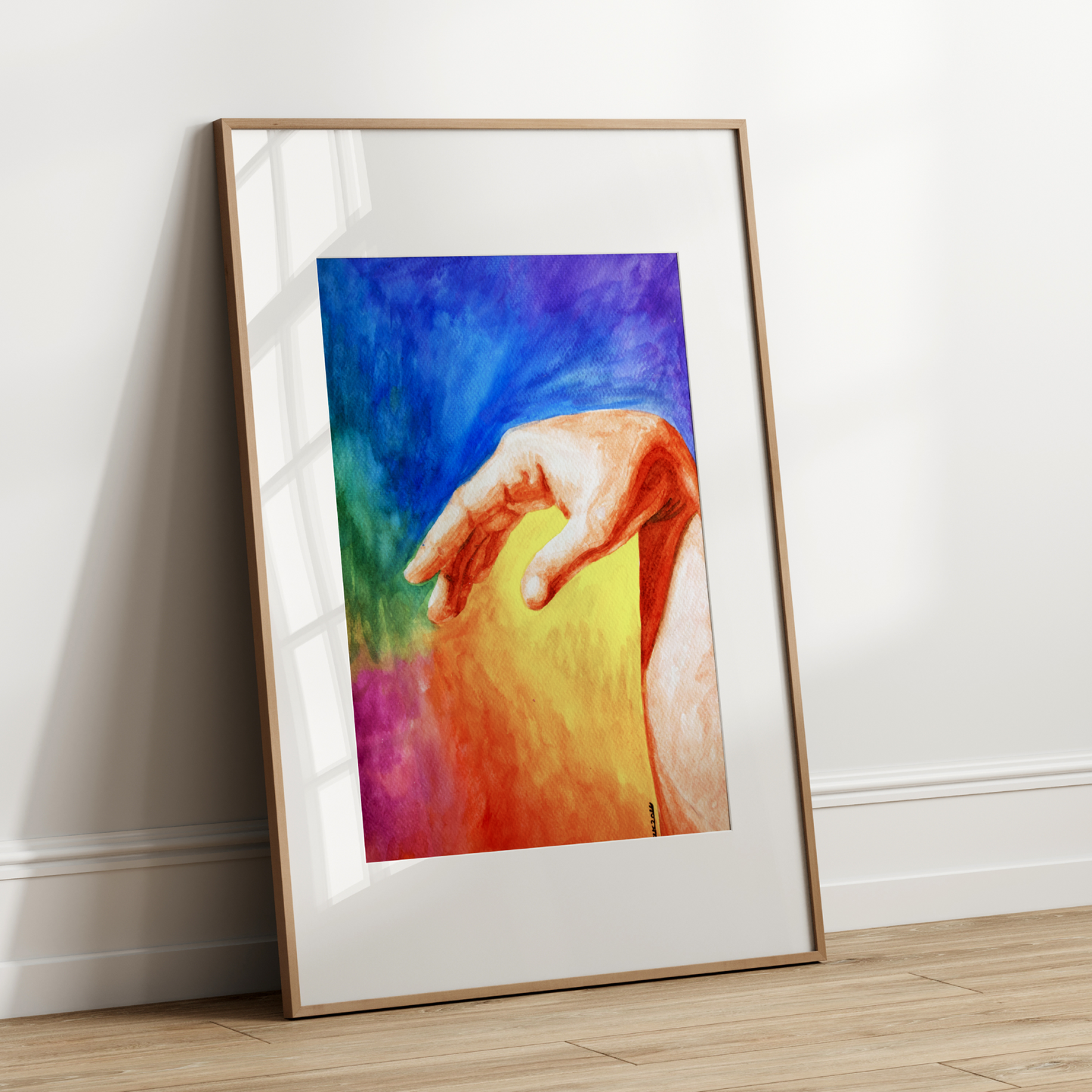 Framed artwork of a colorful hand on a white wall