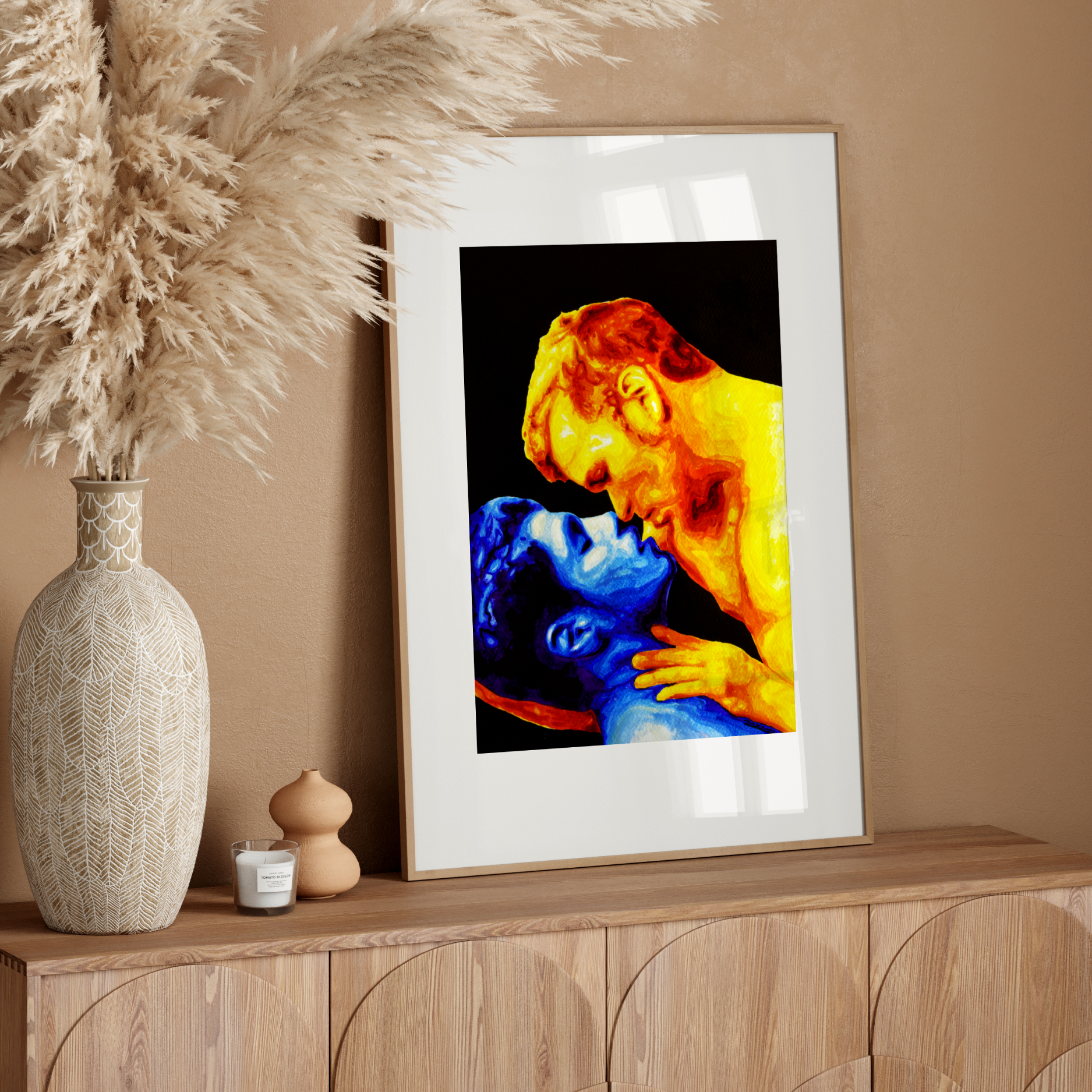 Framed artwork of a colorful depiction of a gay cople embracing on a white wall.