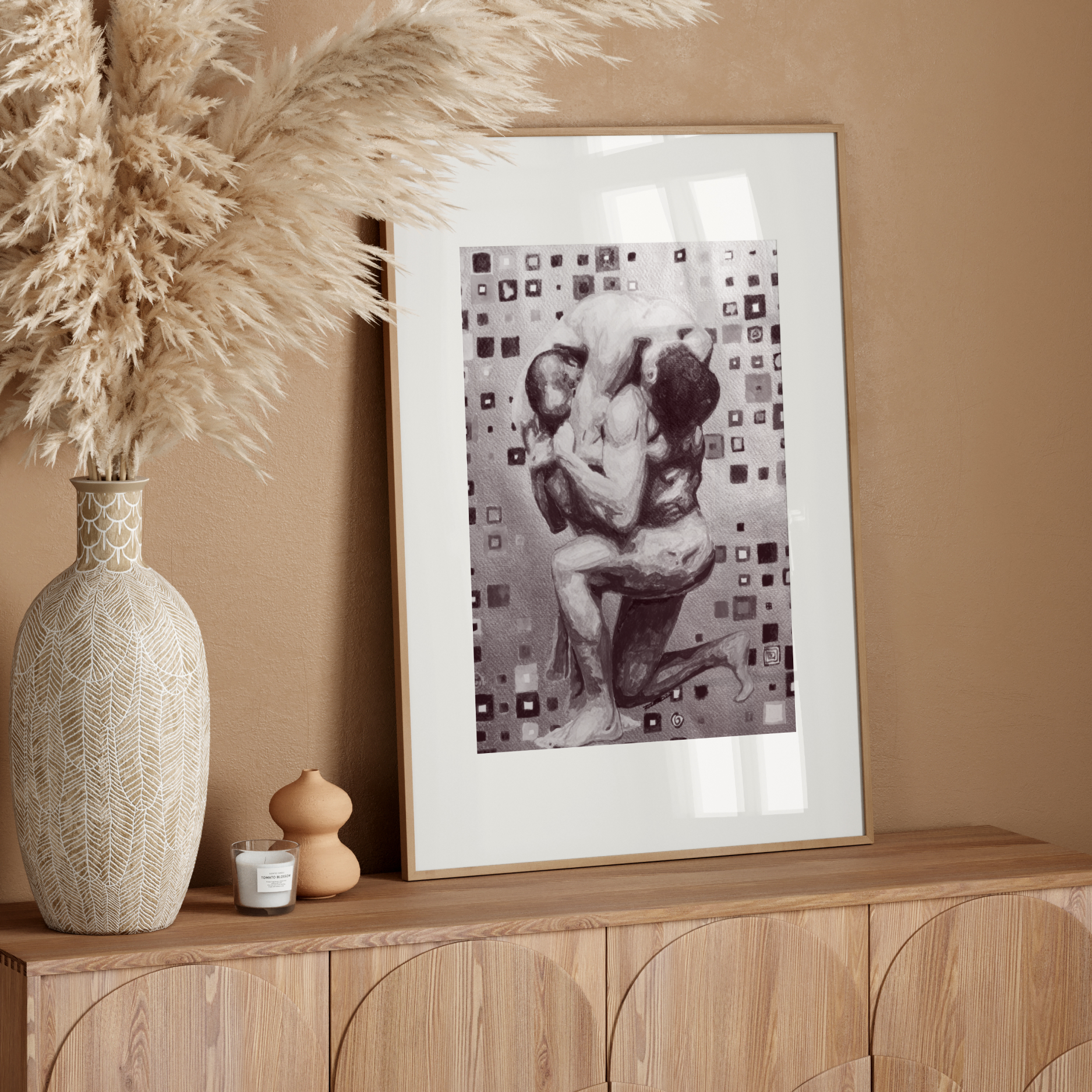 Framed artwork on a wooden sideboard with decorative vase and pampas grass.