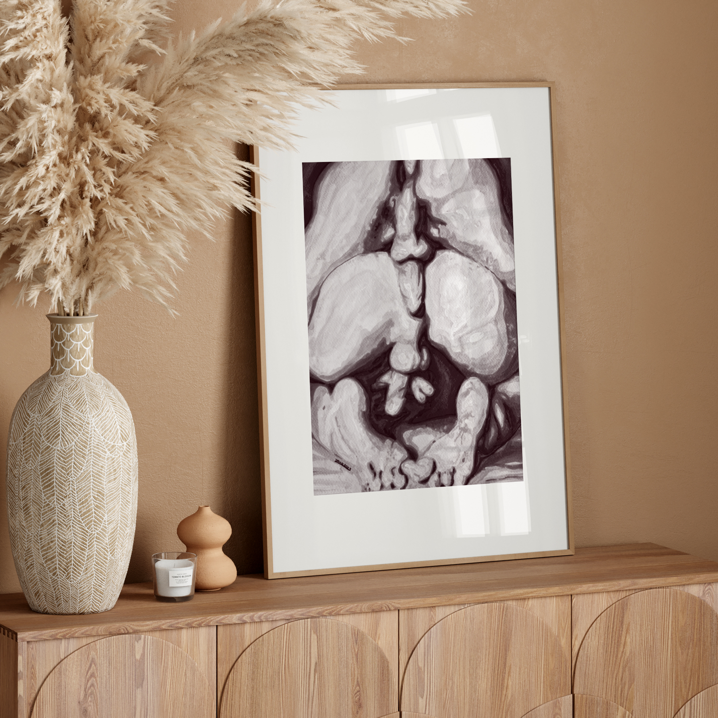 Framed artwork on a wooden sideboard with decorative elements against a beige wall.