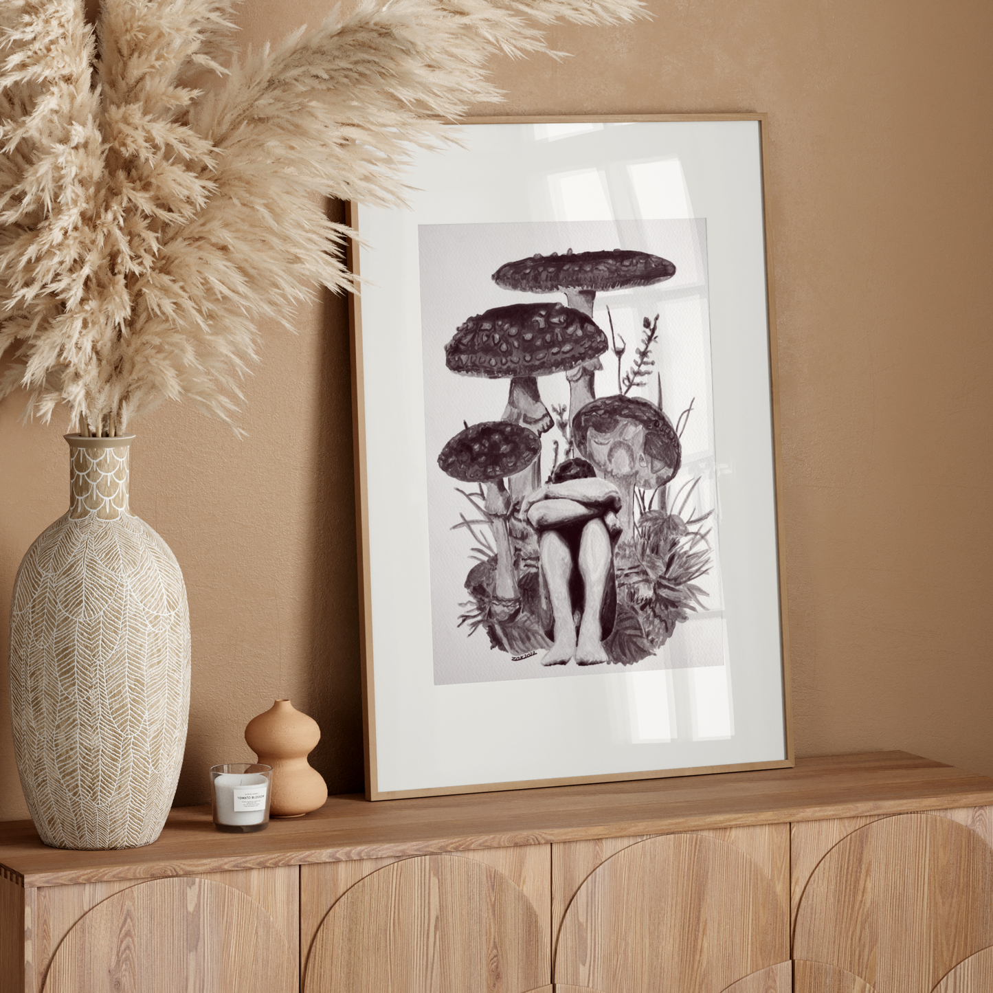 Framed artwork of mushrooms on a wooden sideboard with decorative elements.