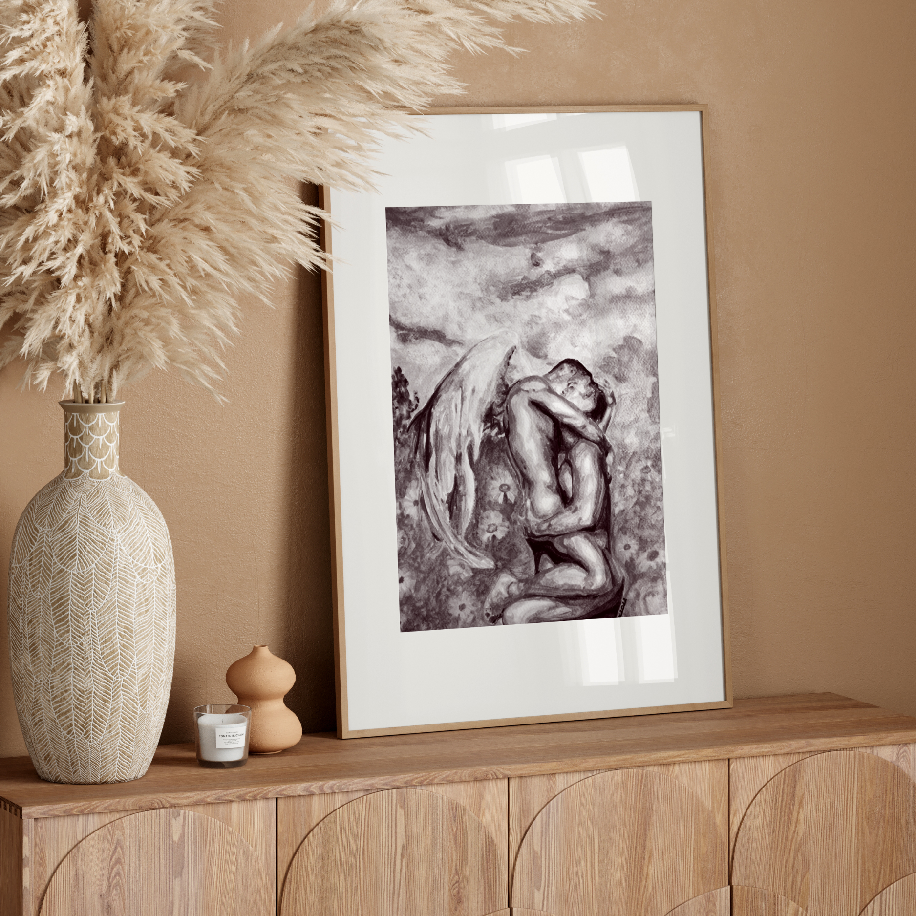 Framed artwork on a wooden console table with decorative elements against a beige wall.
