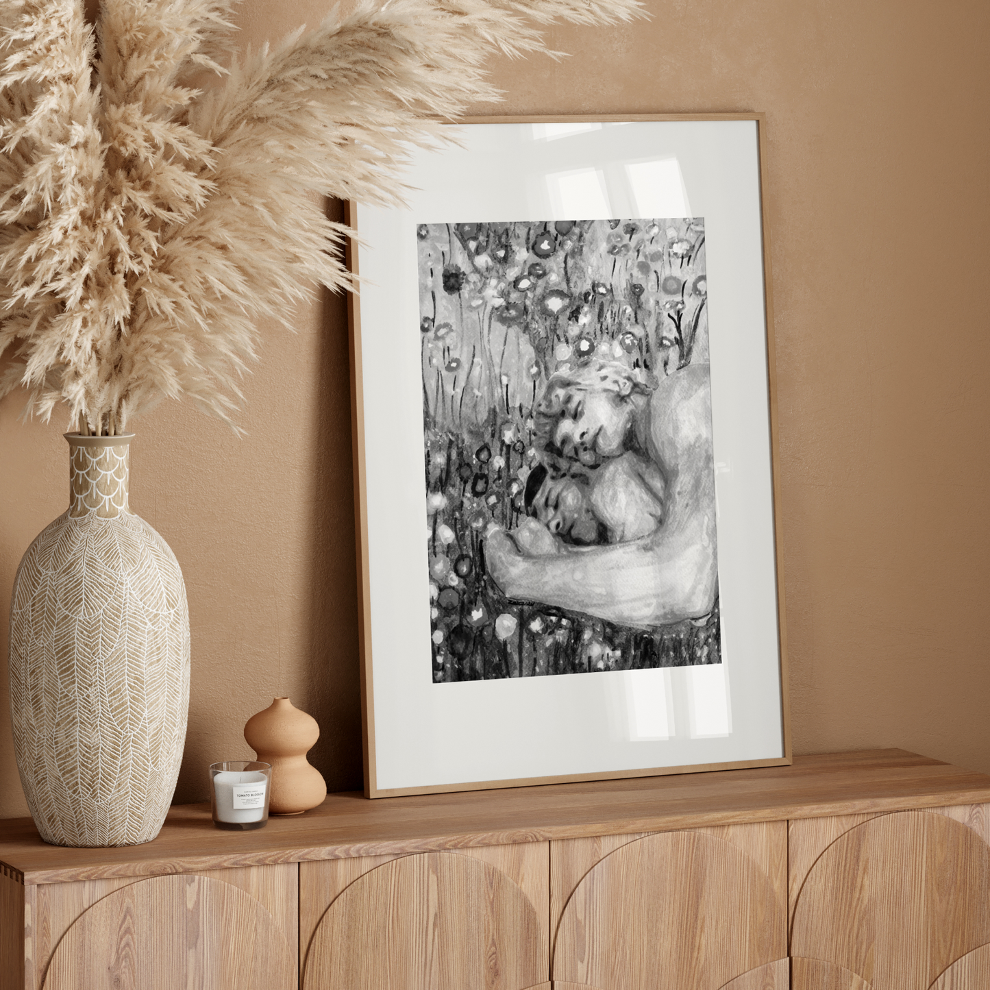 Framed artwork on a wooden console table with decorative elements against a beige wall.