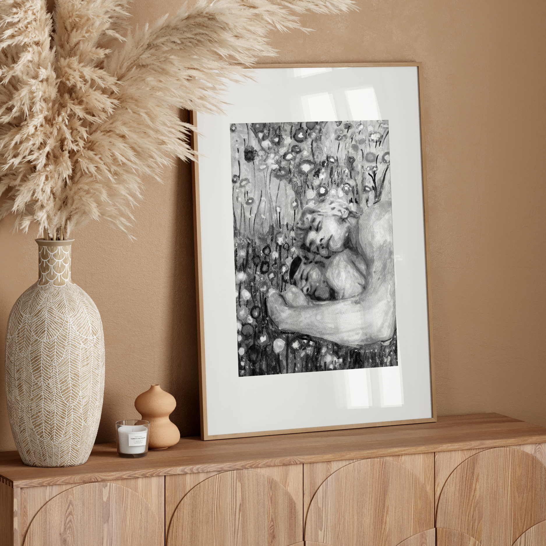 Framed artwork on a wooden console table with decorative elements against a beige wall.