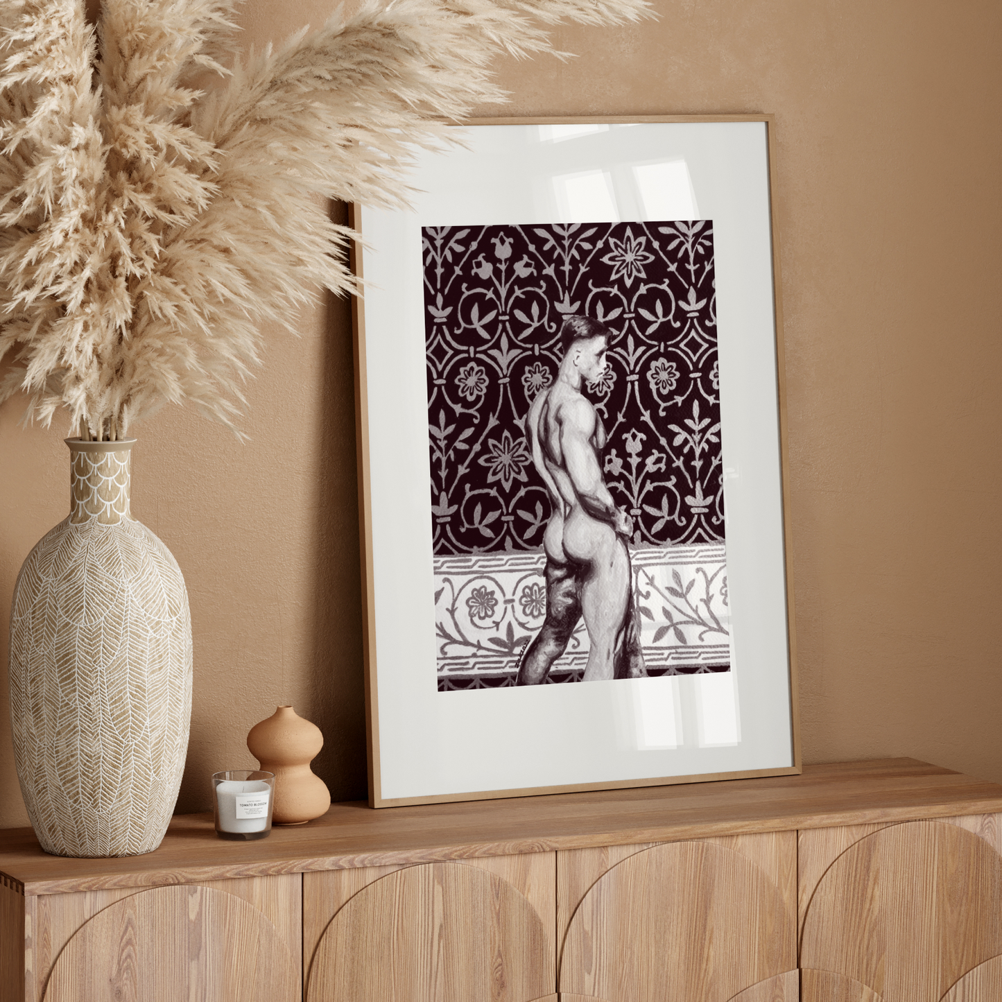 Framed artwork of a nude figure on a wooden sideboard with decorative elements.