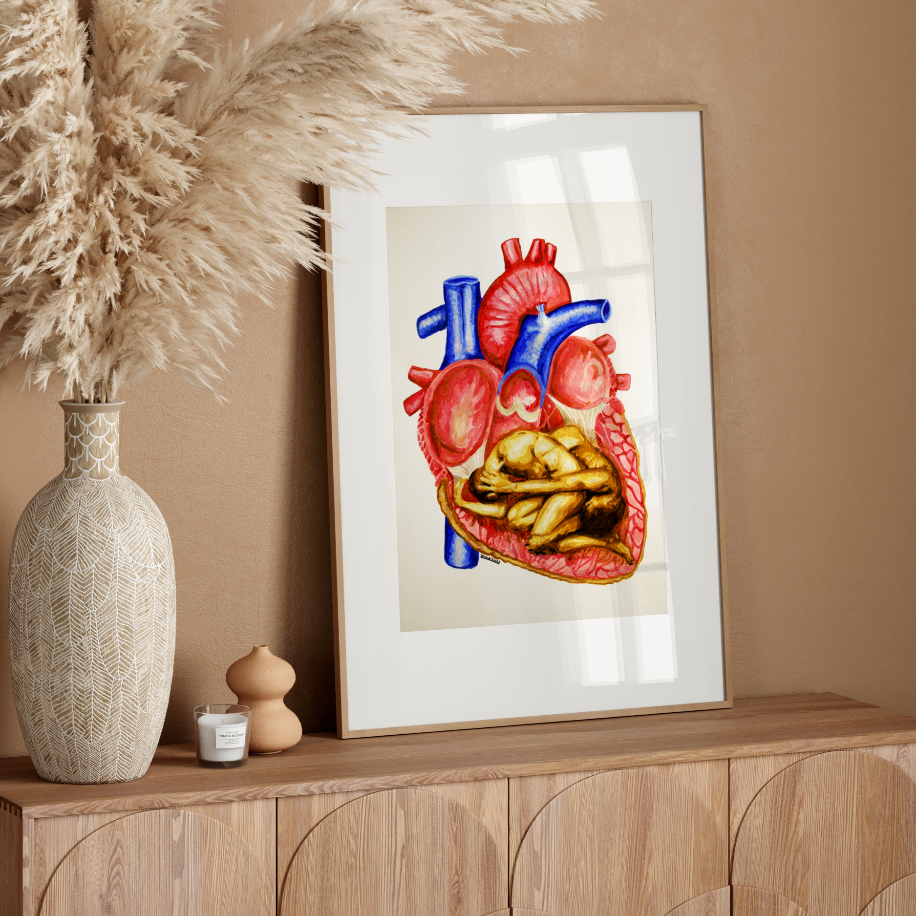 Framed artwork of a heart with food inside on a wooden sideboard against a beige wall.