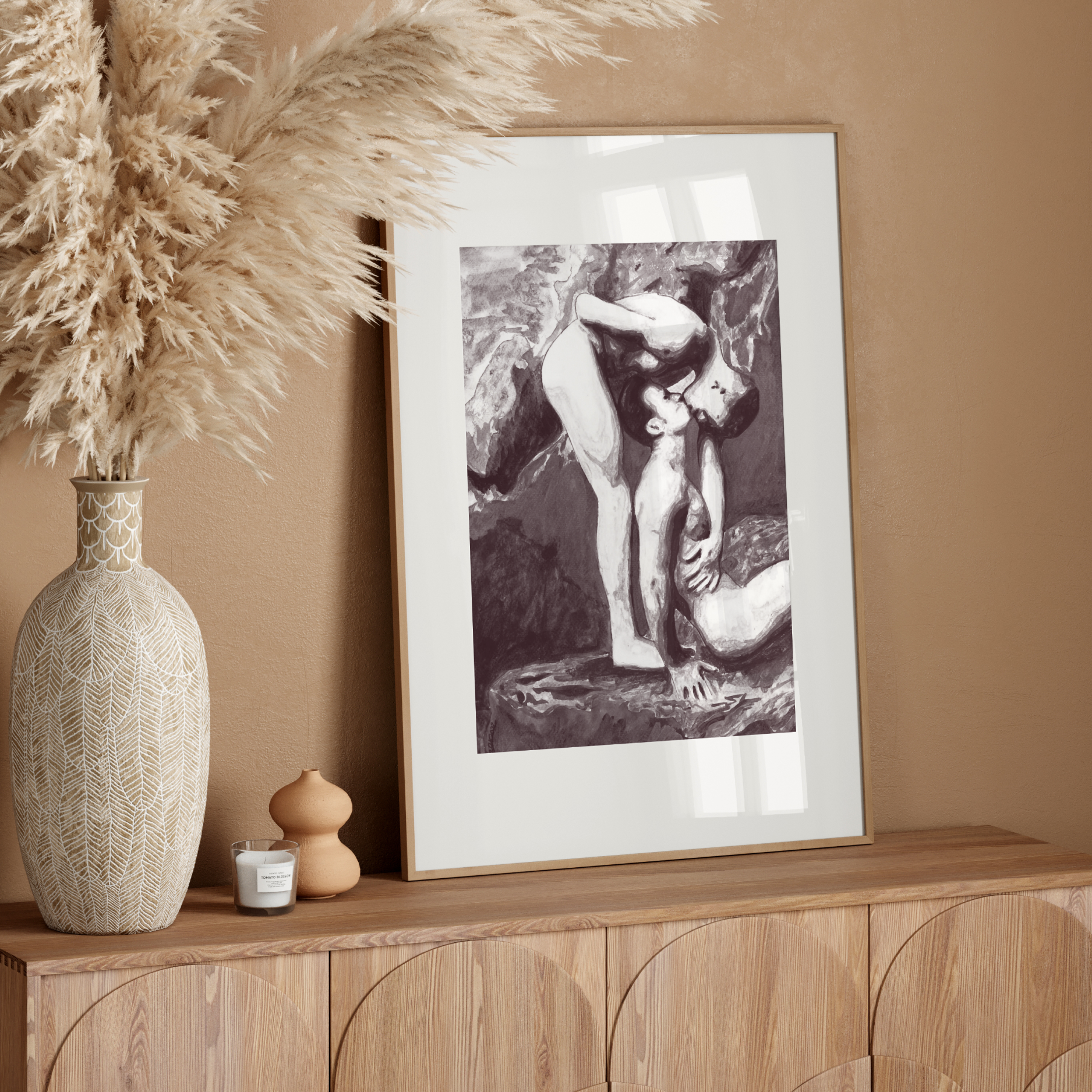 Framed artwork on a wooden console table with decorative elements against a beige wall.