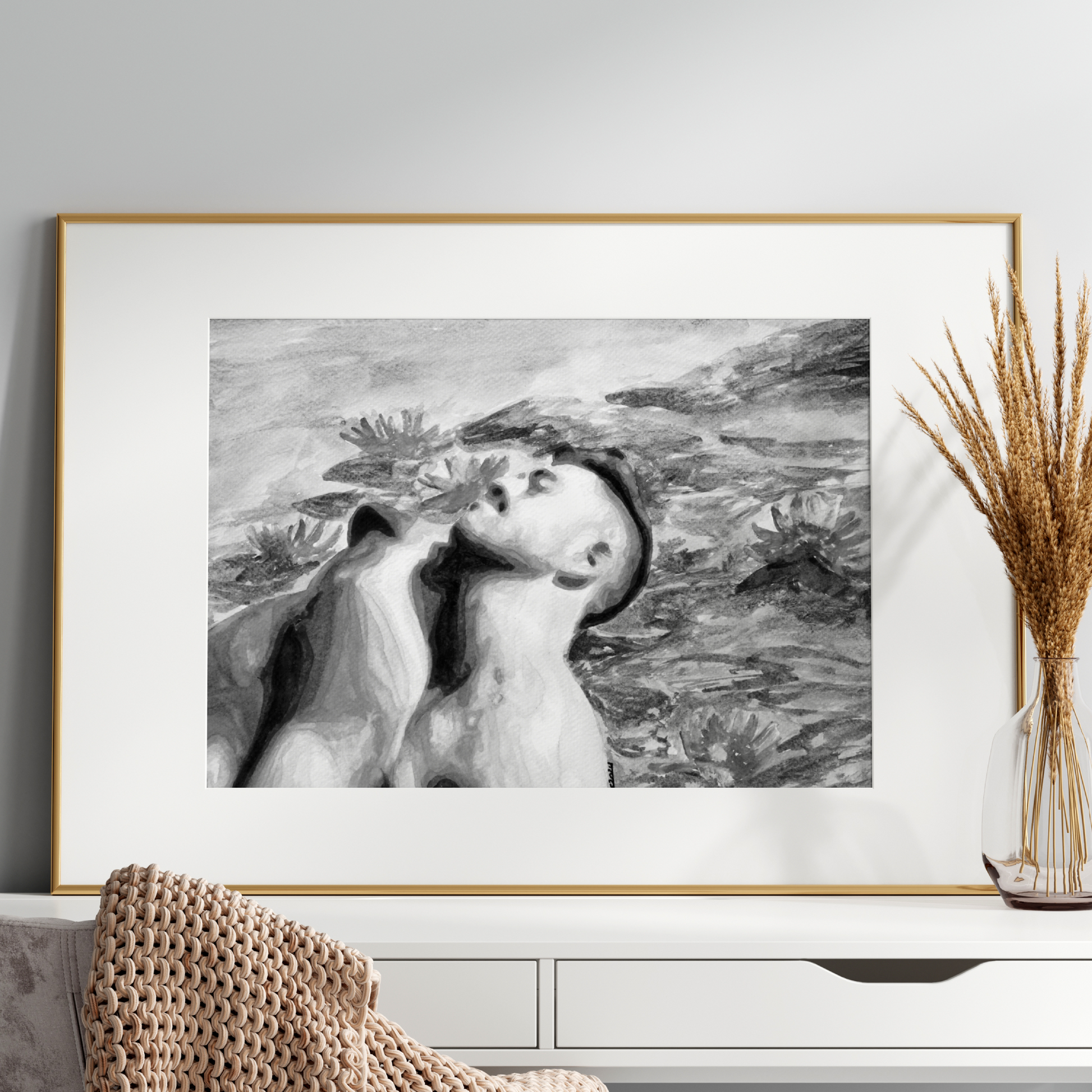 Framed black and white artwork on a wall above a white console table with decorative elements.