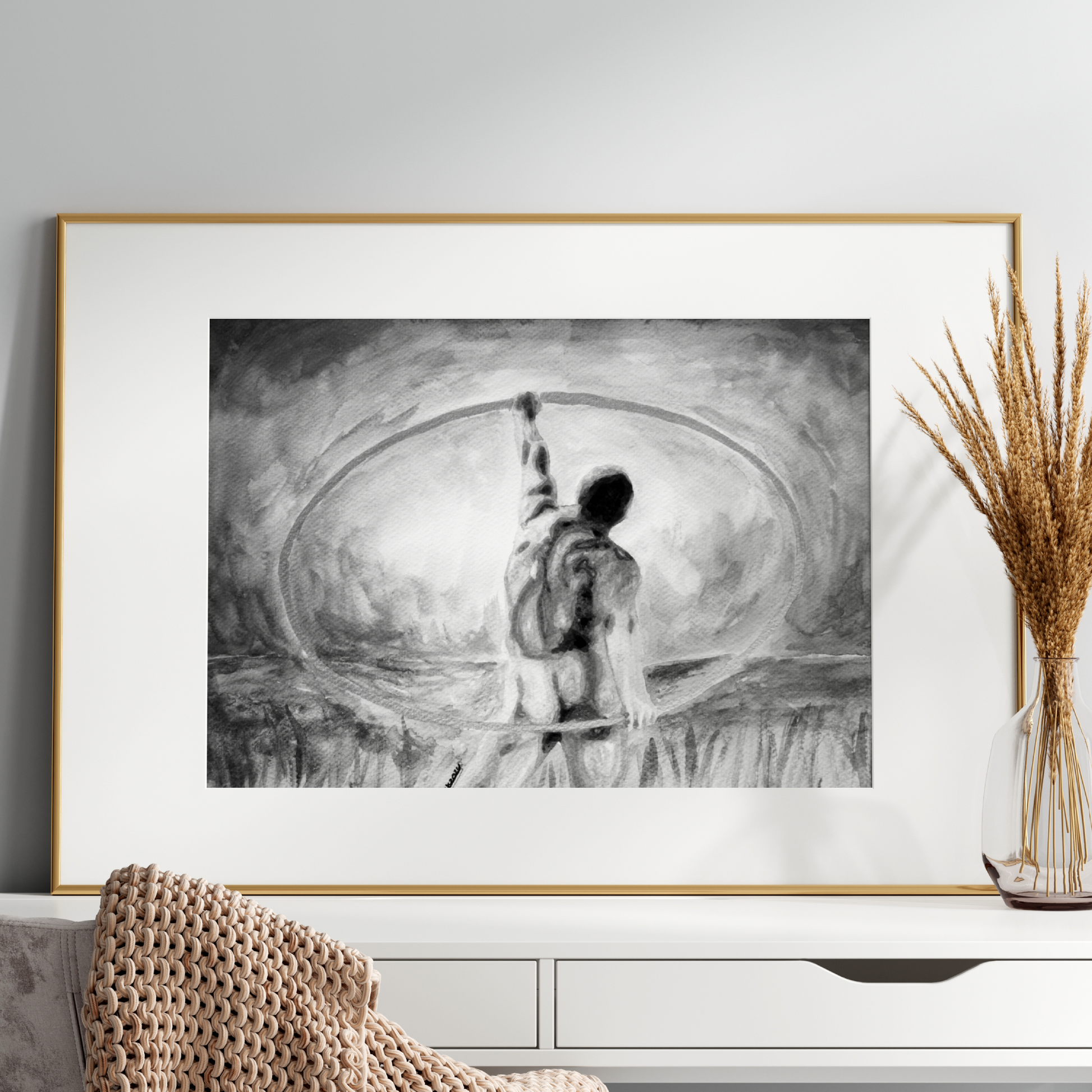 Framed black and white artwork of a person standing on a disc on a white shelf.