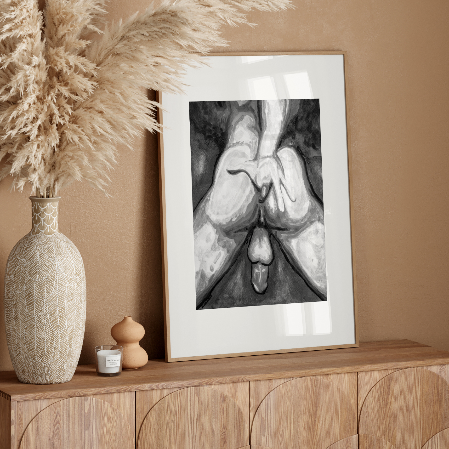 Framed artwork on a wooden sideboard with decorative elements against a beige wall.