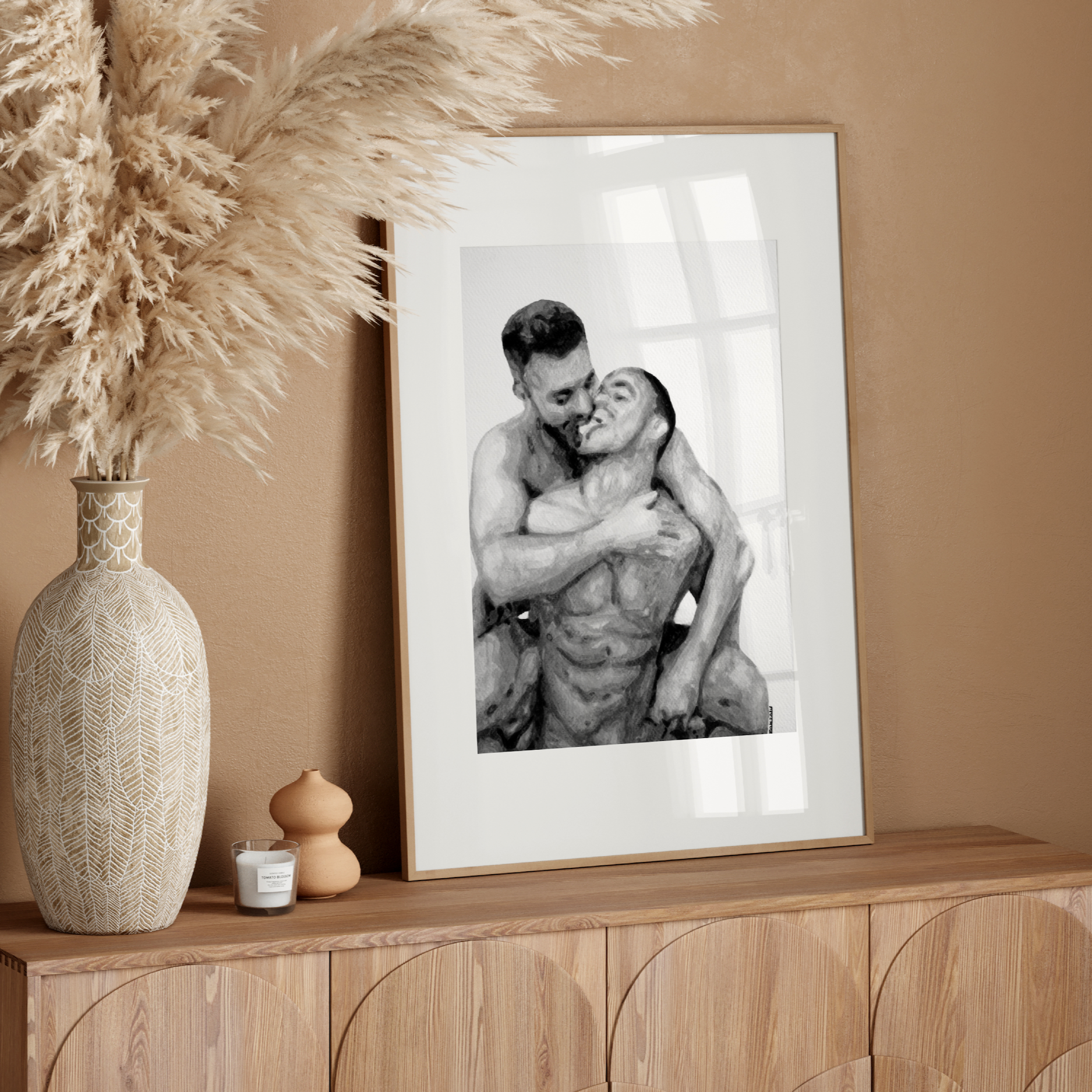 Framed black and white photo of a couple embracing on a wooden console table with decorative elements.