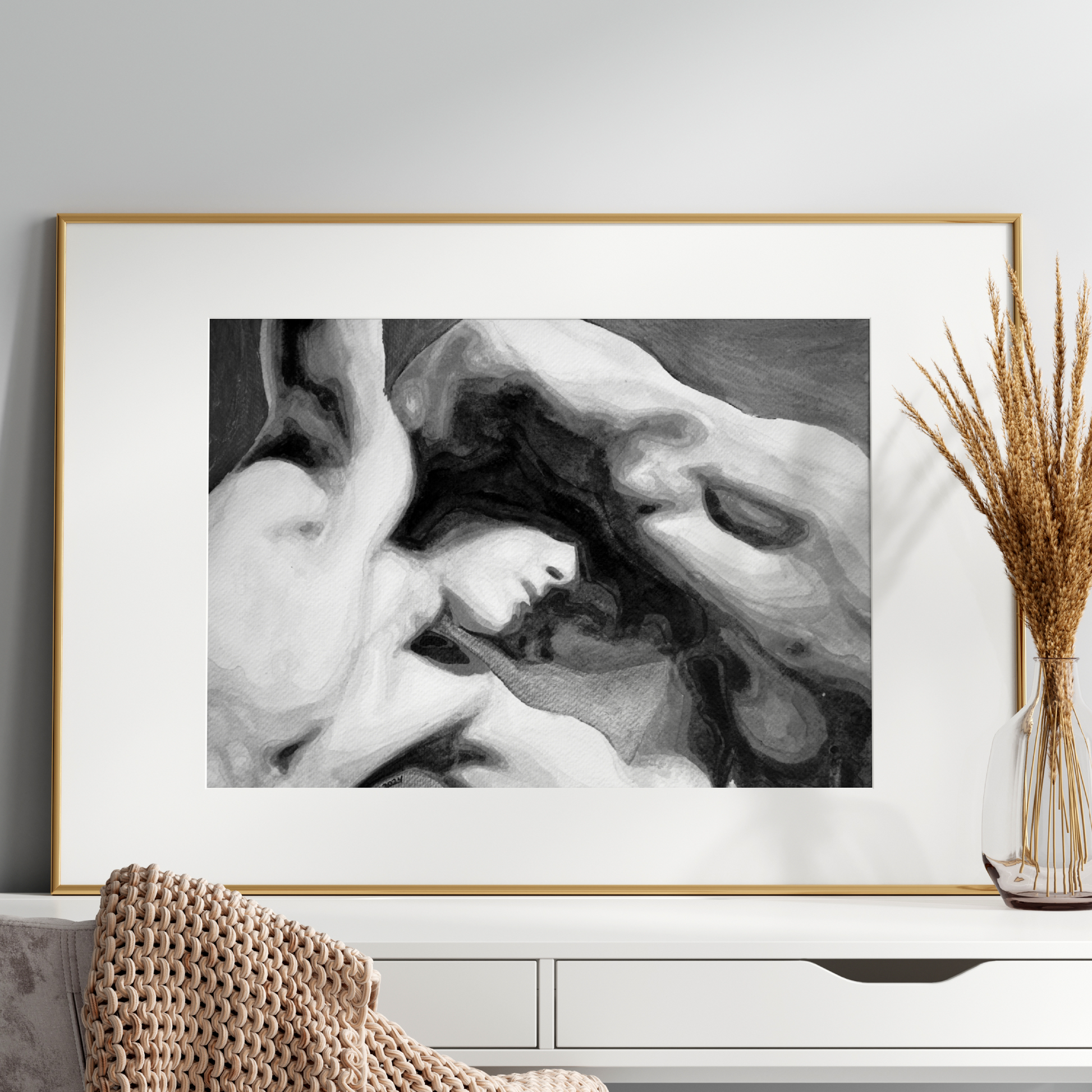 Framed black and white artwork on a wall above a white console table with decorative elements.