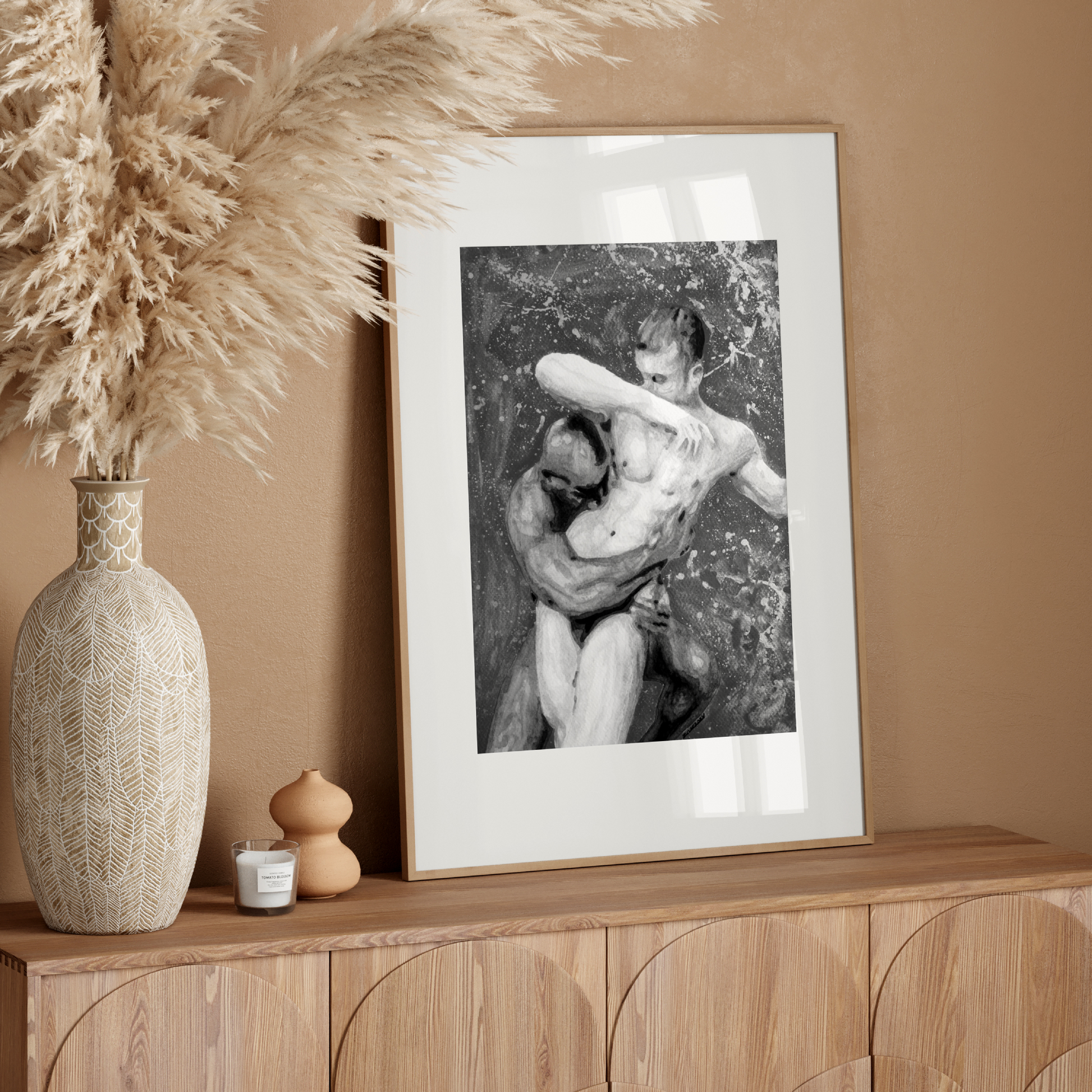 Framed black and white artwork on a wooden console table with decorative elements.