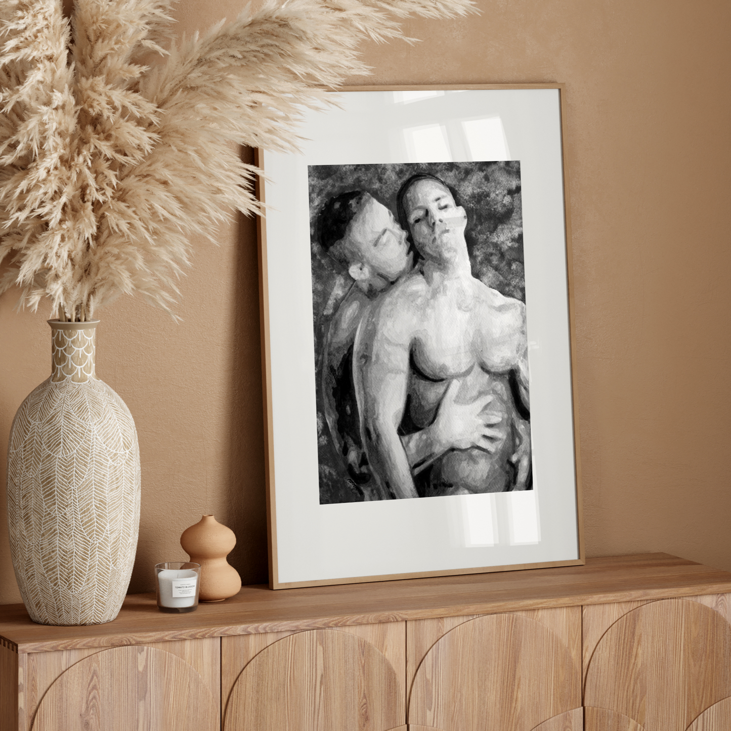 Framed black and white artwork on a wooden sideboard with decorative elements.