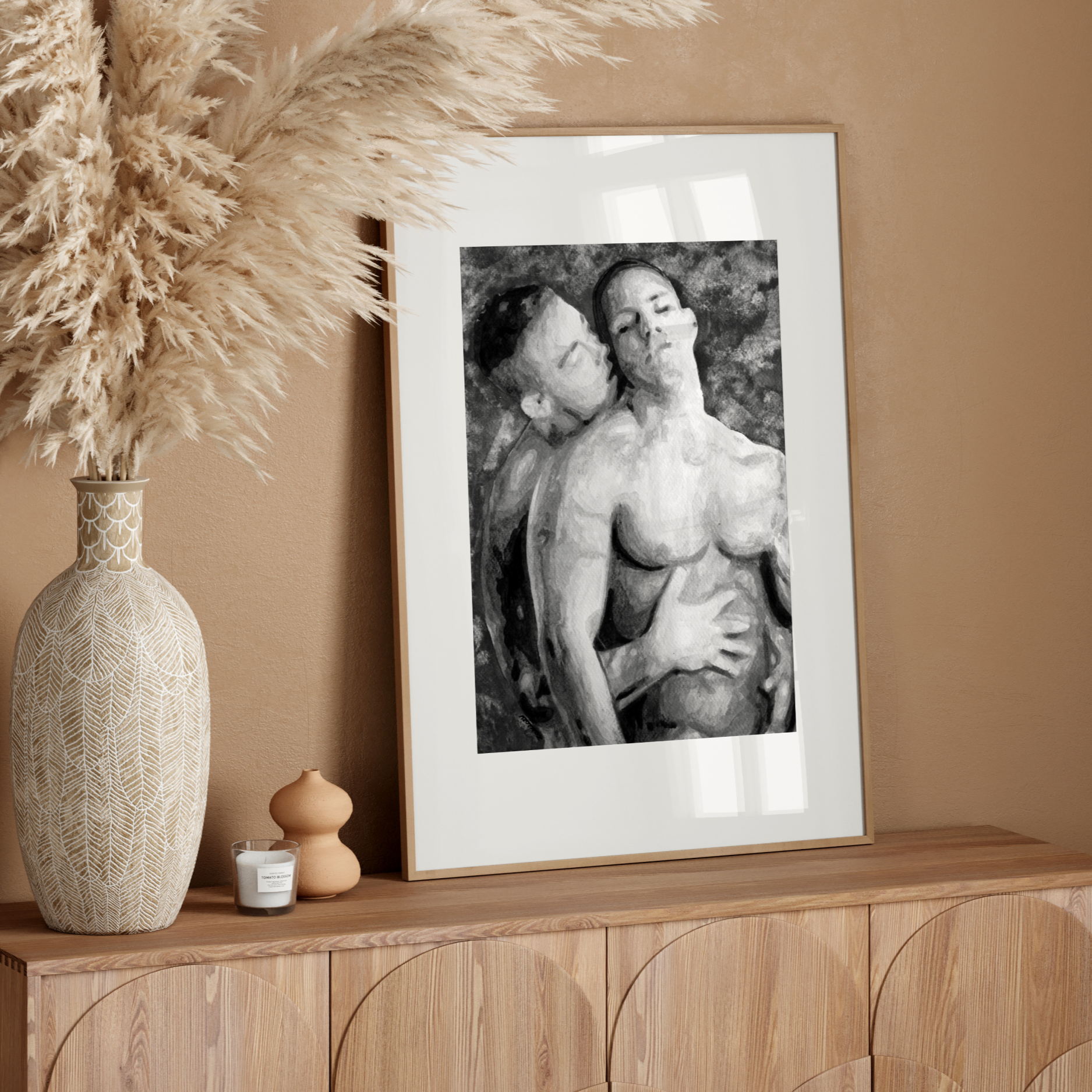 Framed black and white artwork on a wooden sideboard with decorative elements.