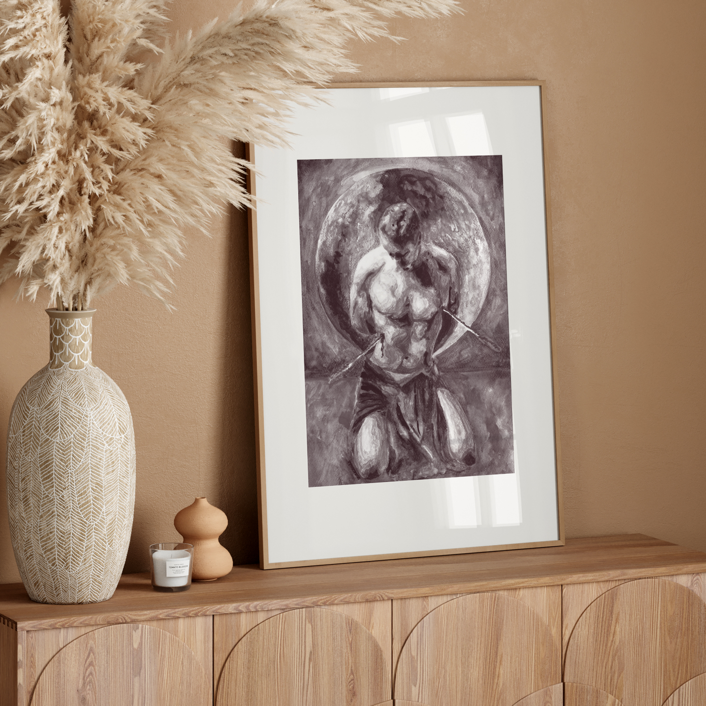 Framed artwork on a wooden console table with decorative elements against a beige wall.