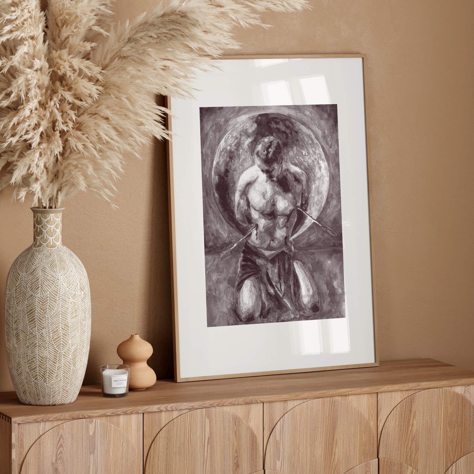 Framed artwork on a wooden console table with decorative elements against a beige wall.