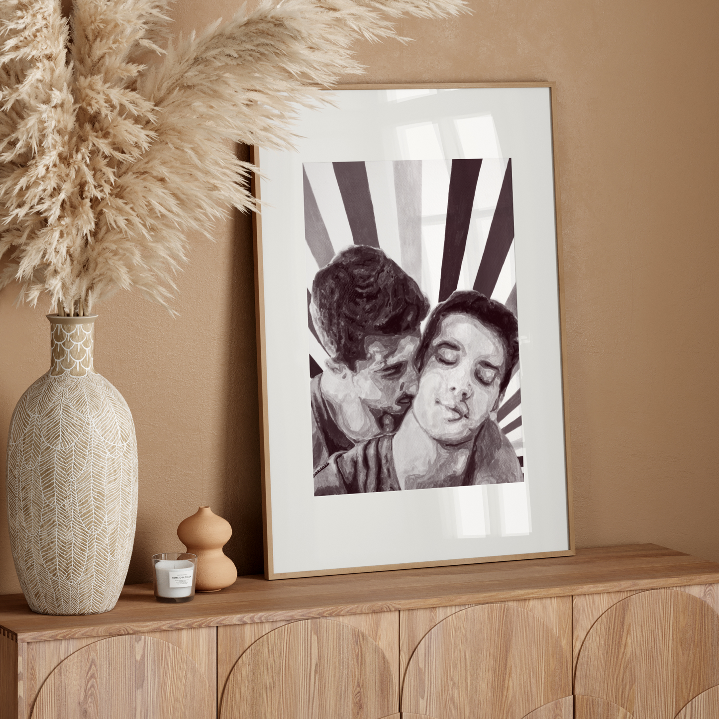 Framed black and white photo of two people embracing on a wooden sideboard with decorative elements.