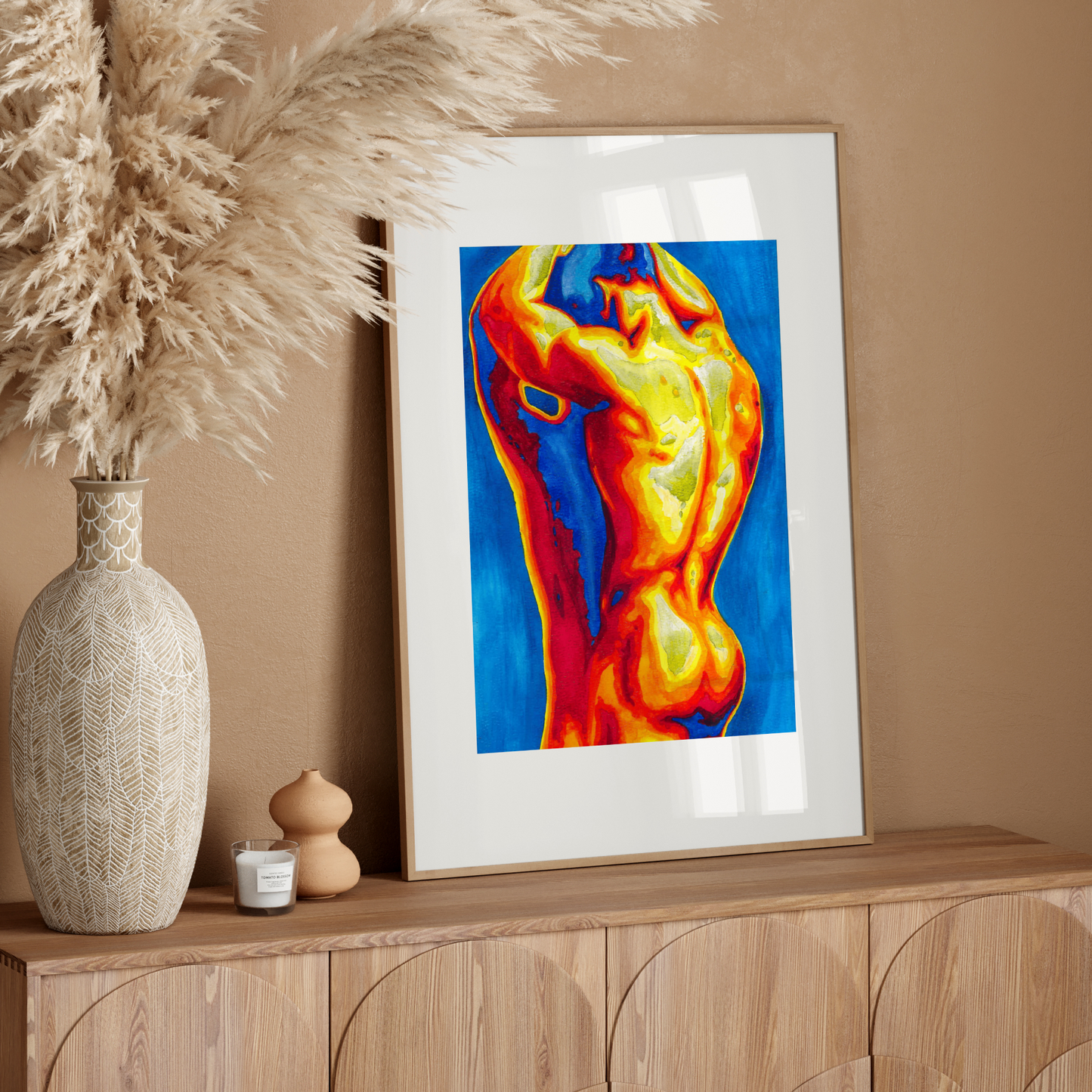 Framed abstract art on a wooden sideboard with decorative elements.