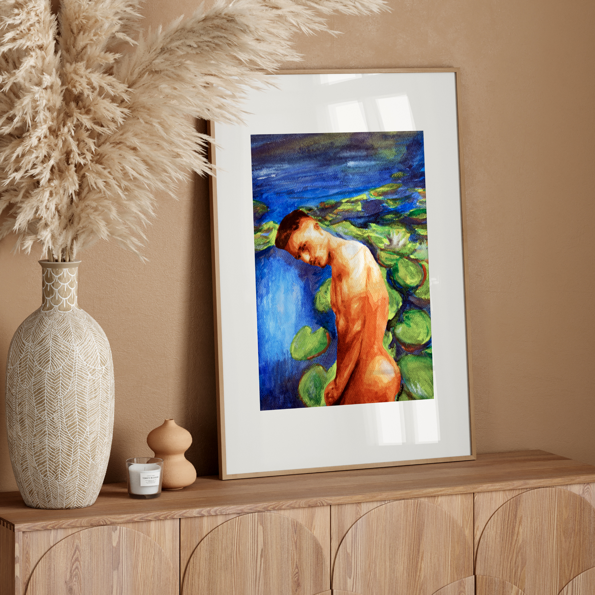 Framed artwork of a nude figure on a wooden sideboard with decorative elements.
