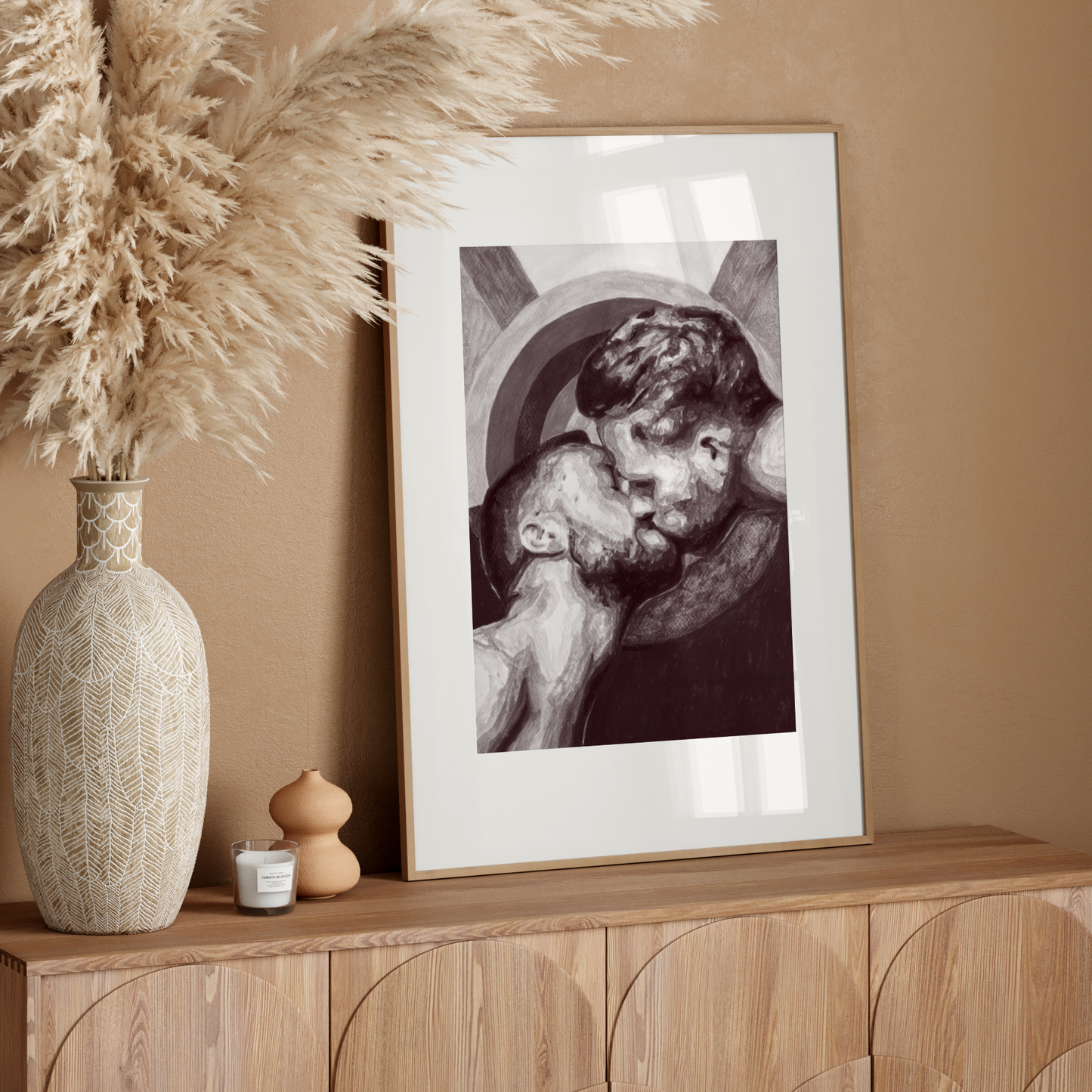 Framed artwork on a wooden console table with decorative elements against a beige wall.