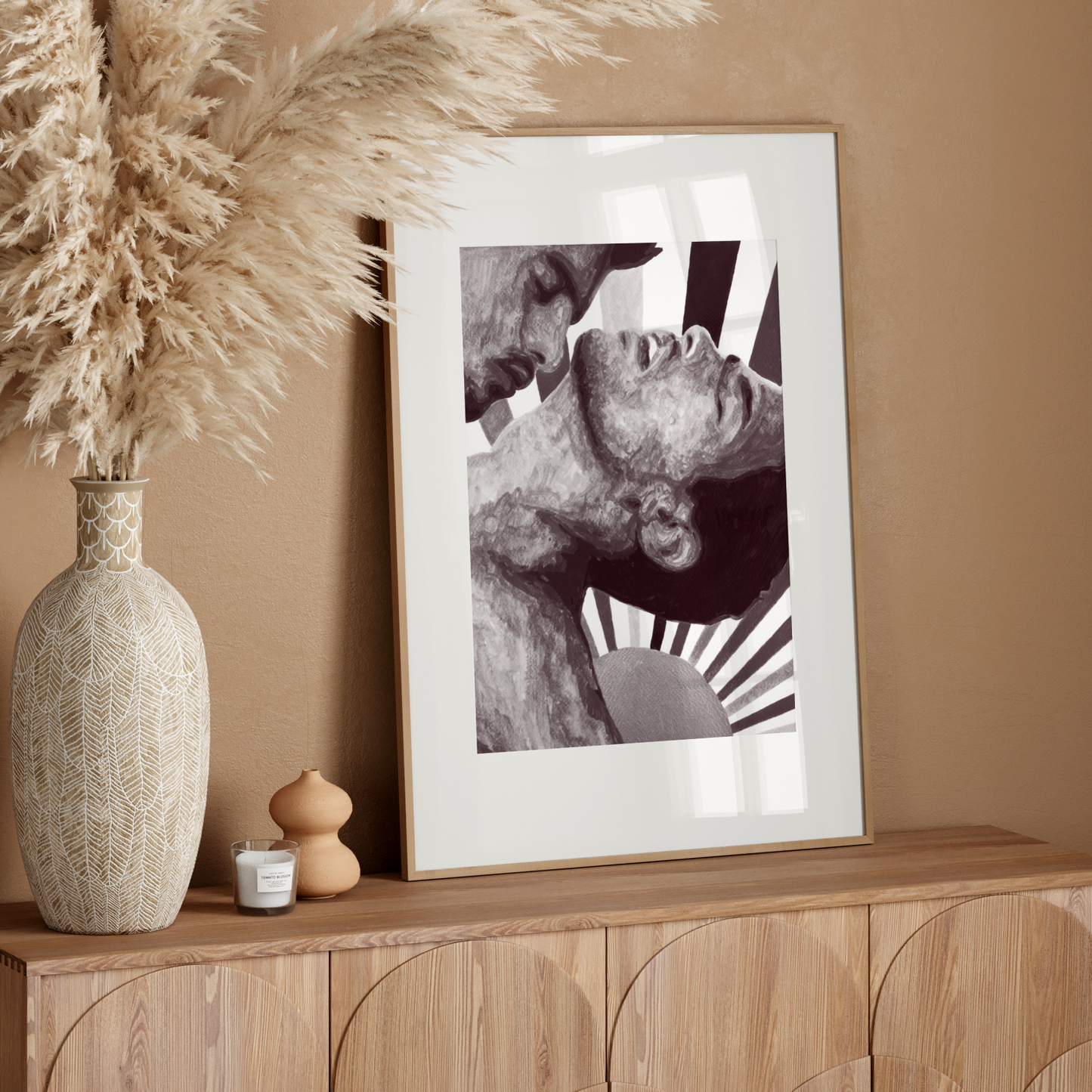 Framed artwork on a wooden sideboard with decorative elements against a beige wall.
