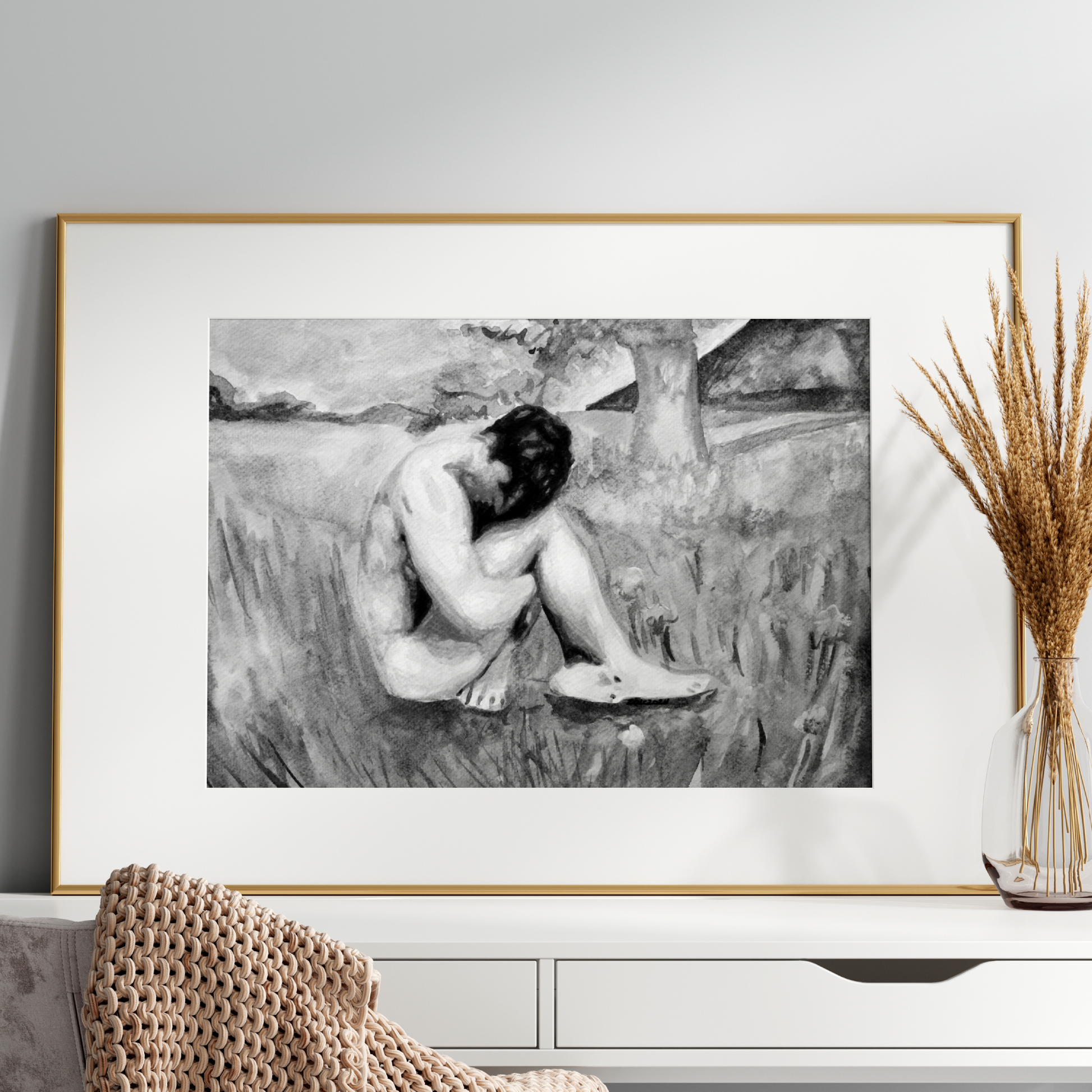Framed black and white artwork of a nude figure on a wall above a white console table.