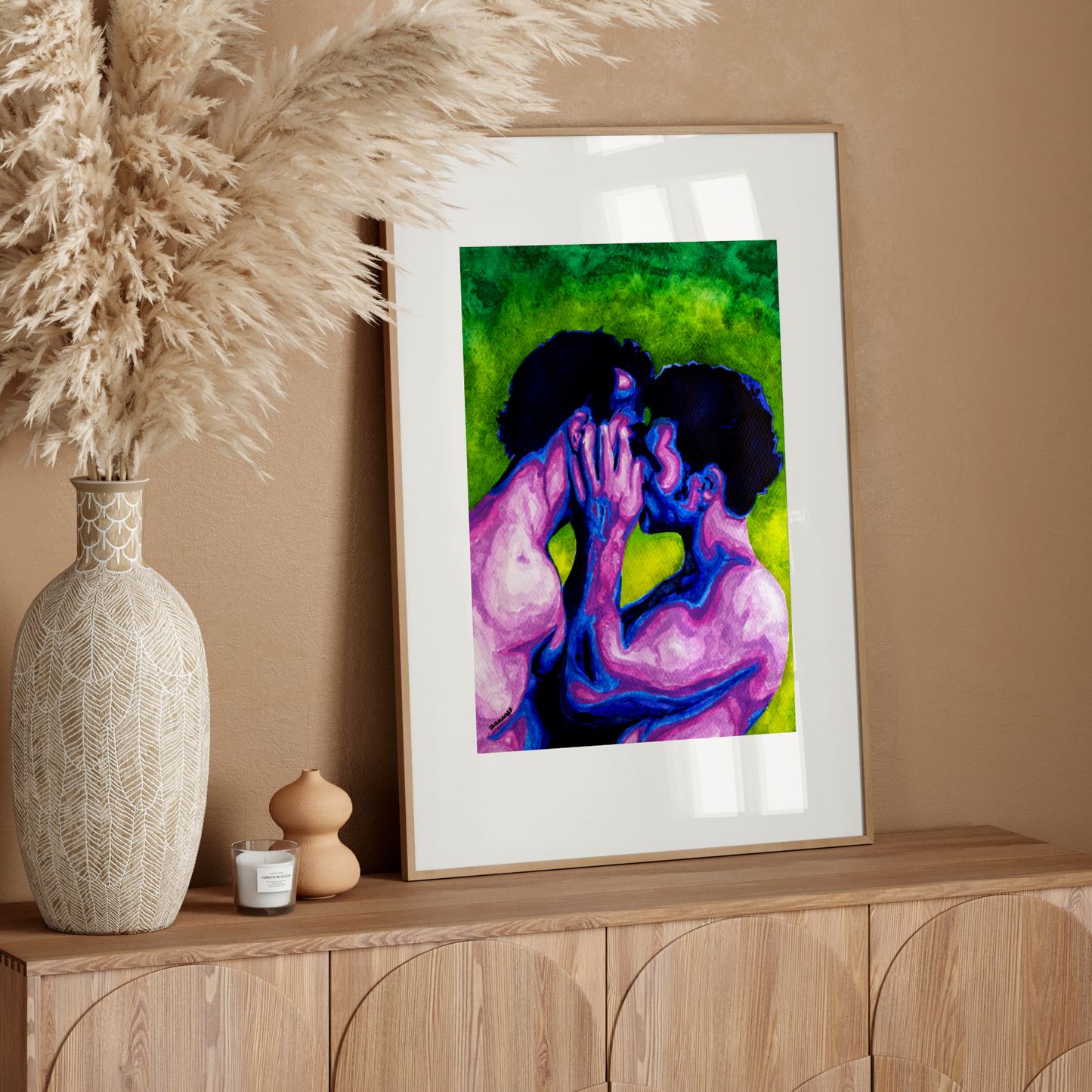 Framed artwork of two people embracing on a wooden sideboard with decorative elements.