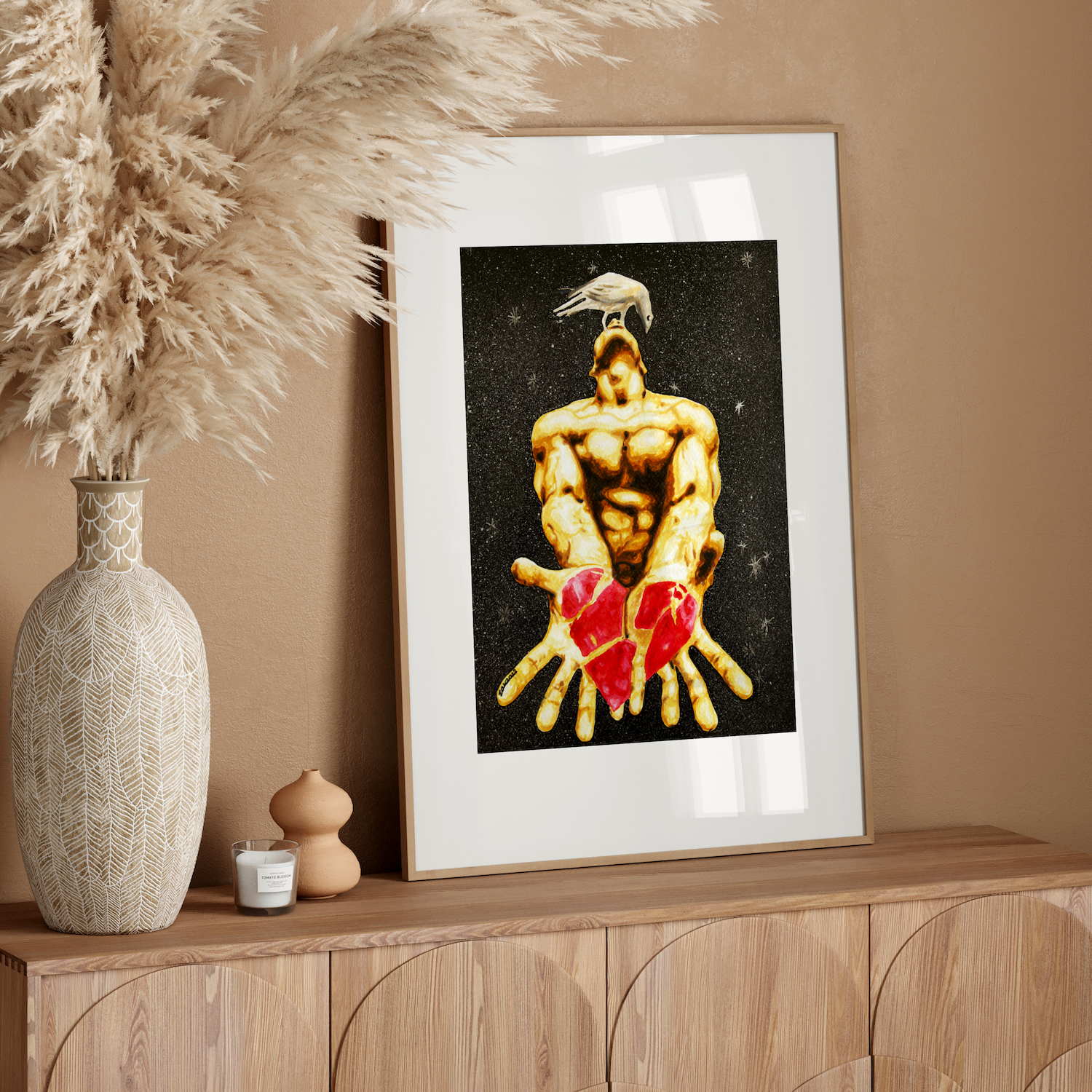 Framed artwork of a muscular figure with a red heart on a wooden console table against a beige wall.