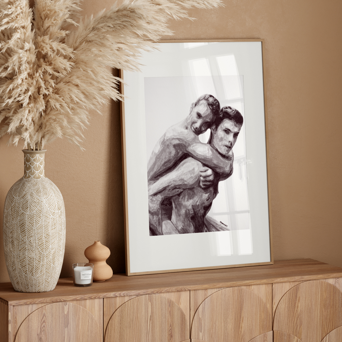 Framed artwork of two people embracing on a wooden sideboard with decorative elements.