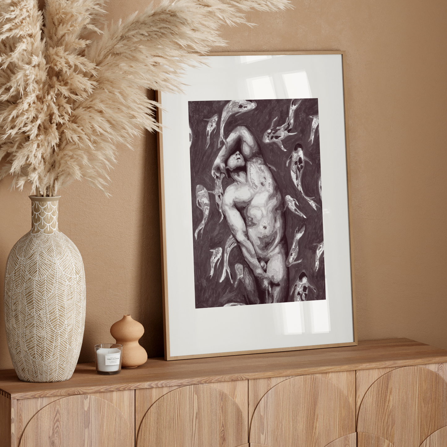 Framed artwork on a wooden console table with decorative elements against a beige wall.