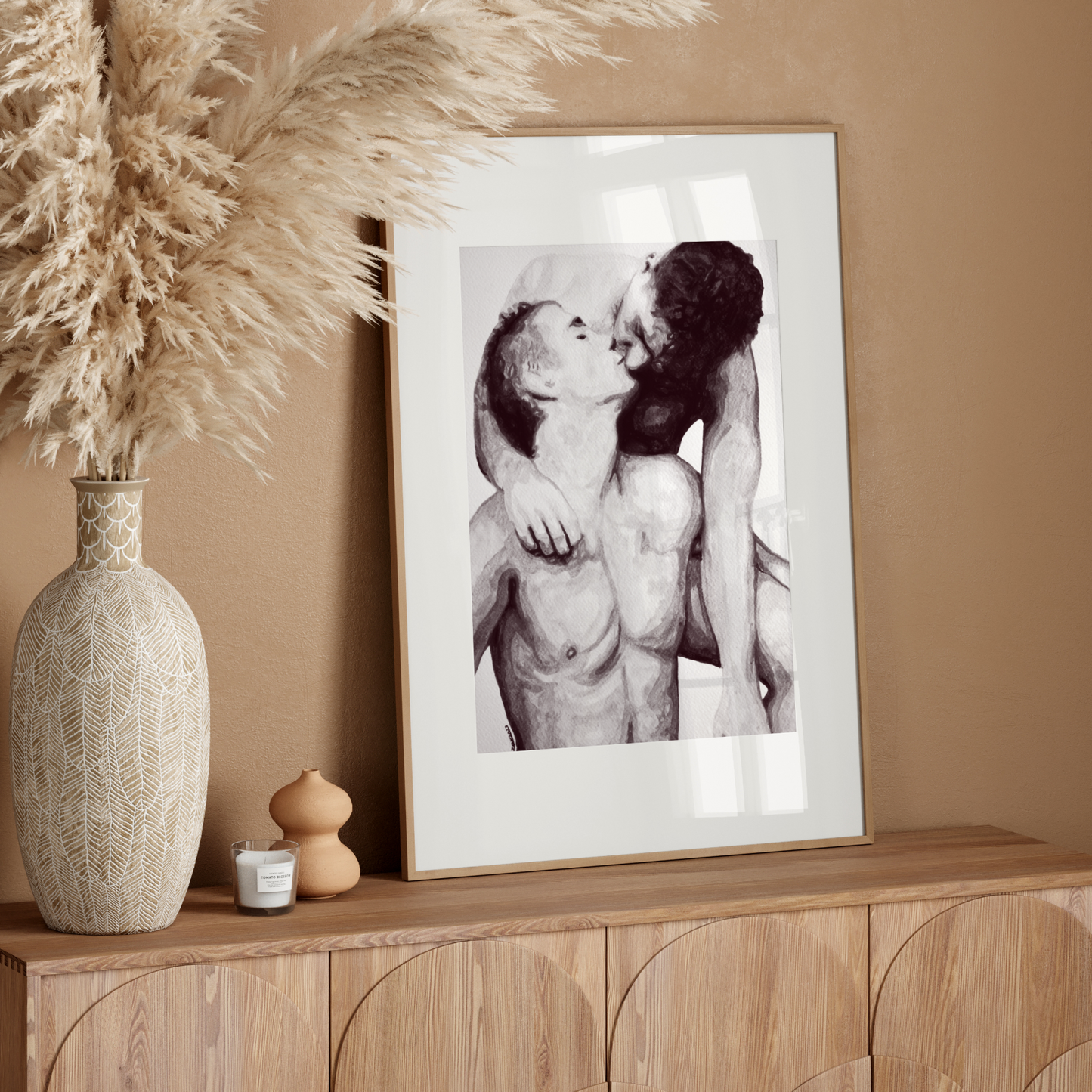Framed black and white artwork on a wooden sideboard with decorative elements.