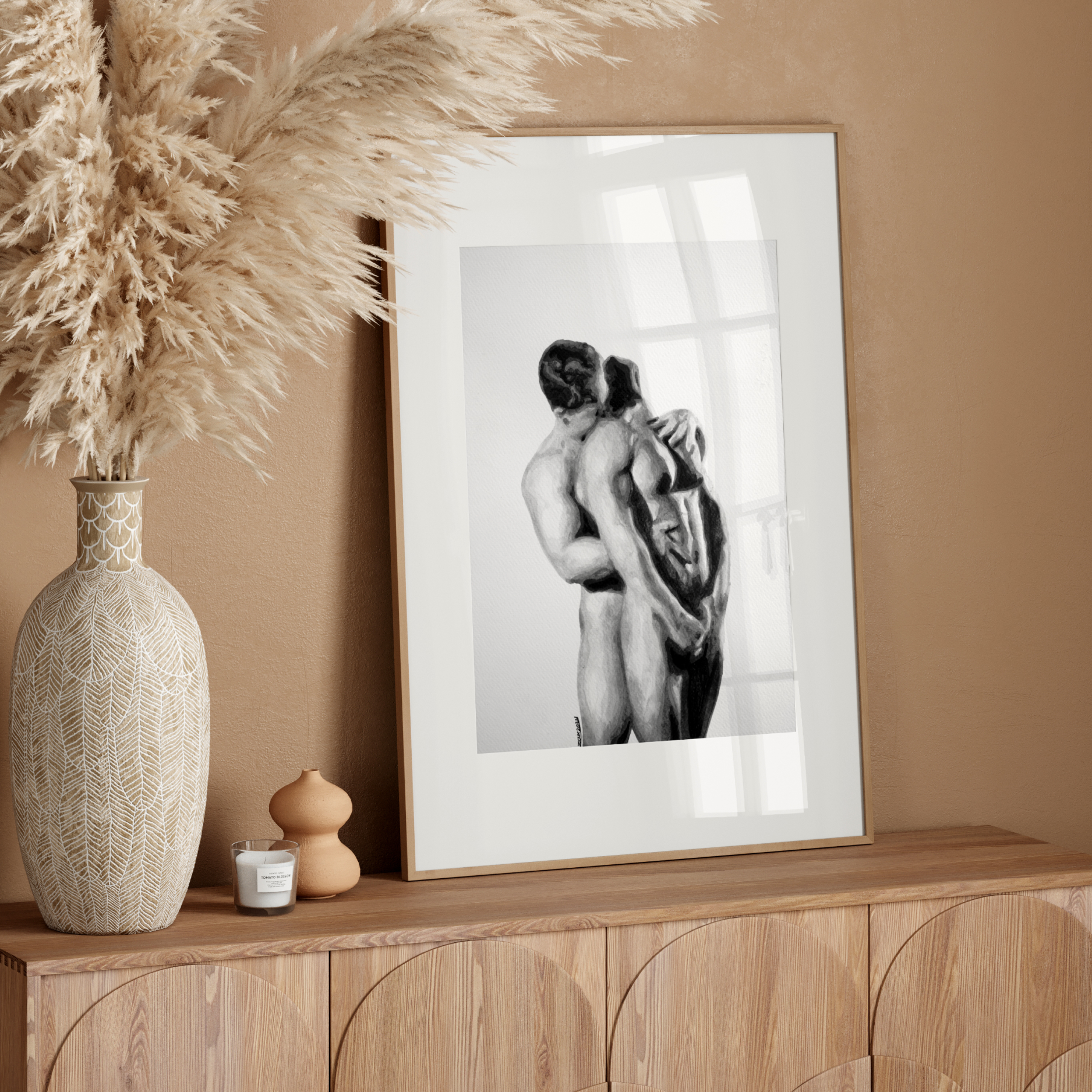 Framed black and white artwork on a wooden console table with decorative elements.
