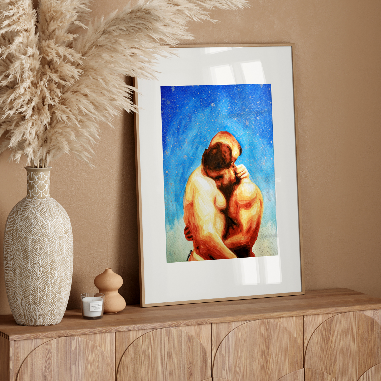 Framed artwork of two people embracing on a wooden sideboard with decorative elements.