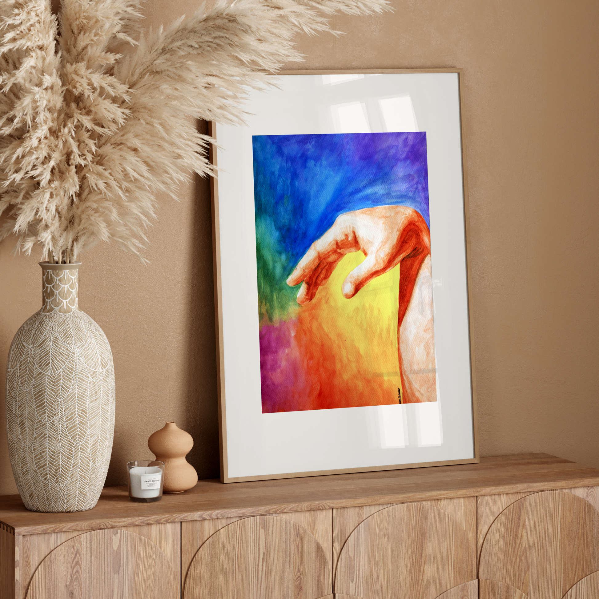Framed colorful artwork on a wooden console table with decorative elements.