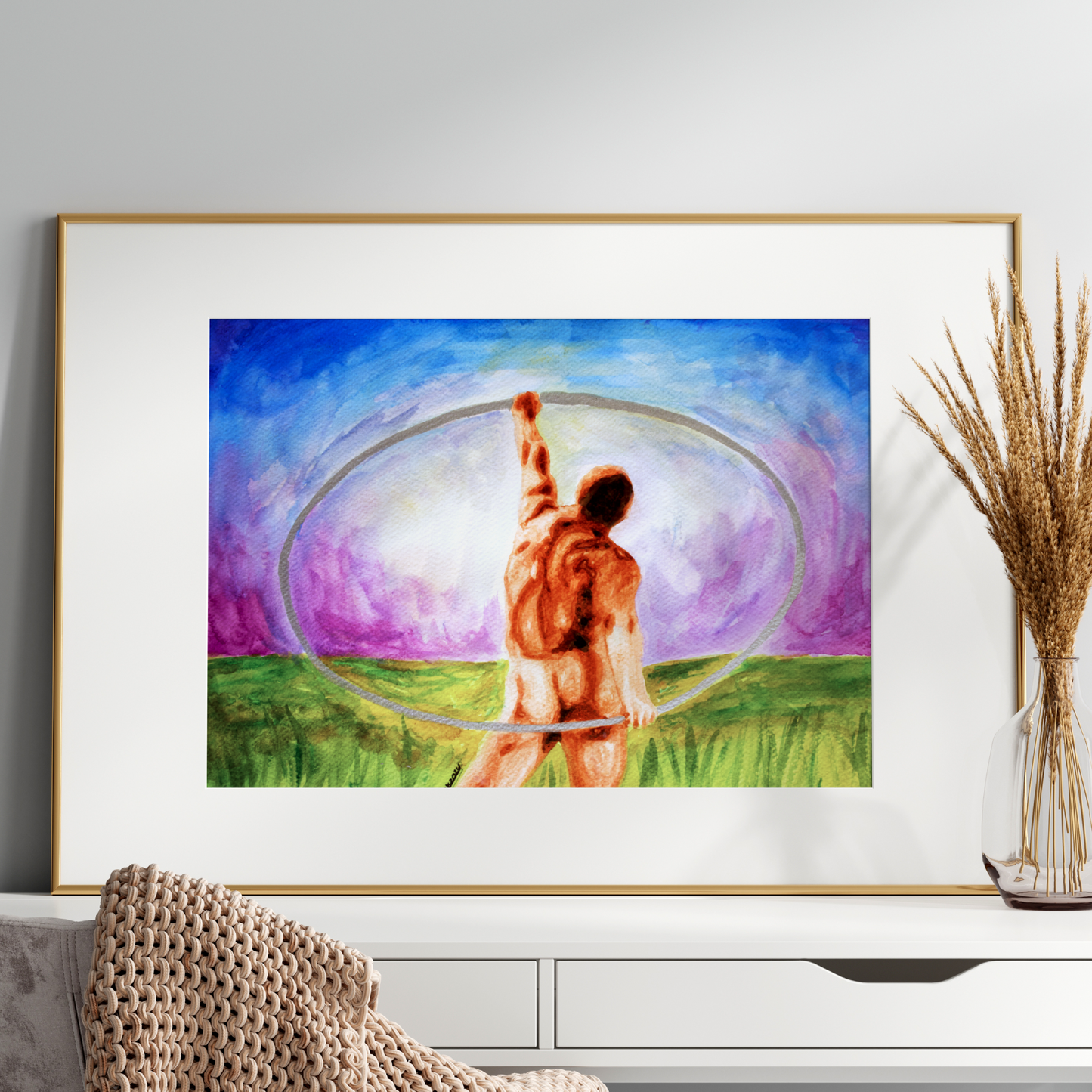 Framed artwork of a person with a hula hoop in a grassy field, displayed on a white surface.