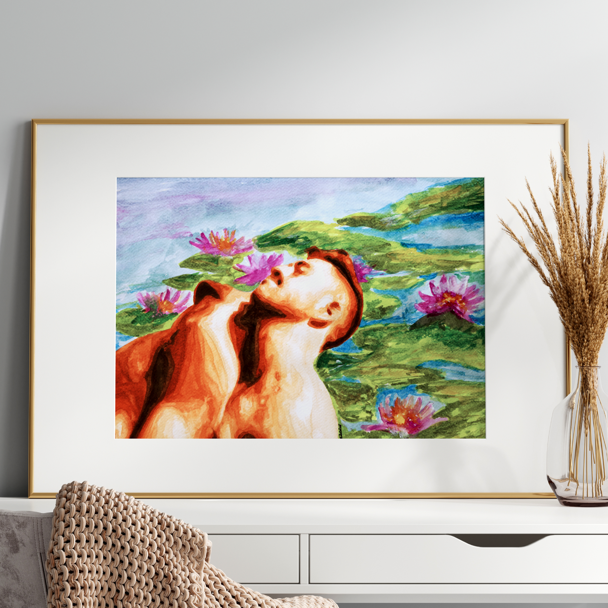 Framed artwork of a woman and horse with water lilies on a wall above a white cabinet.
