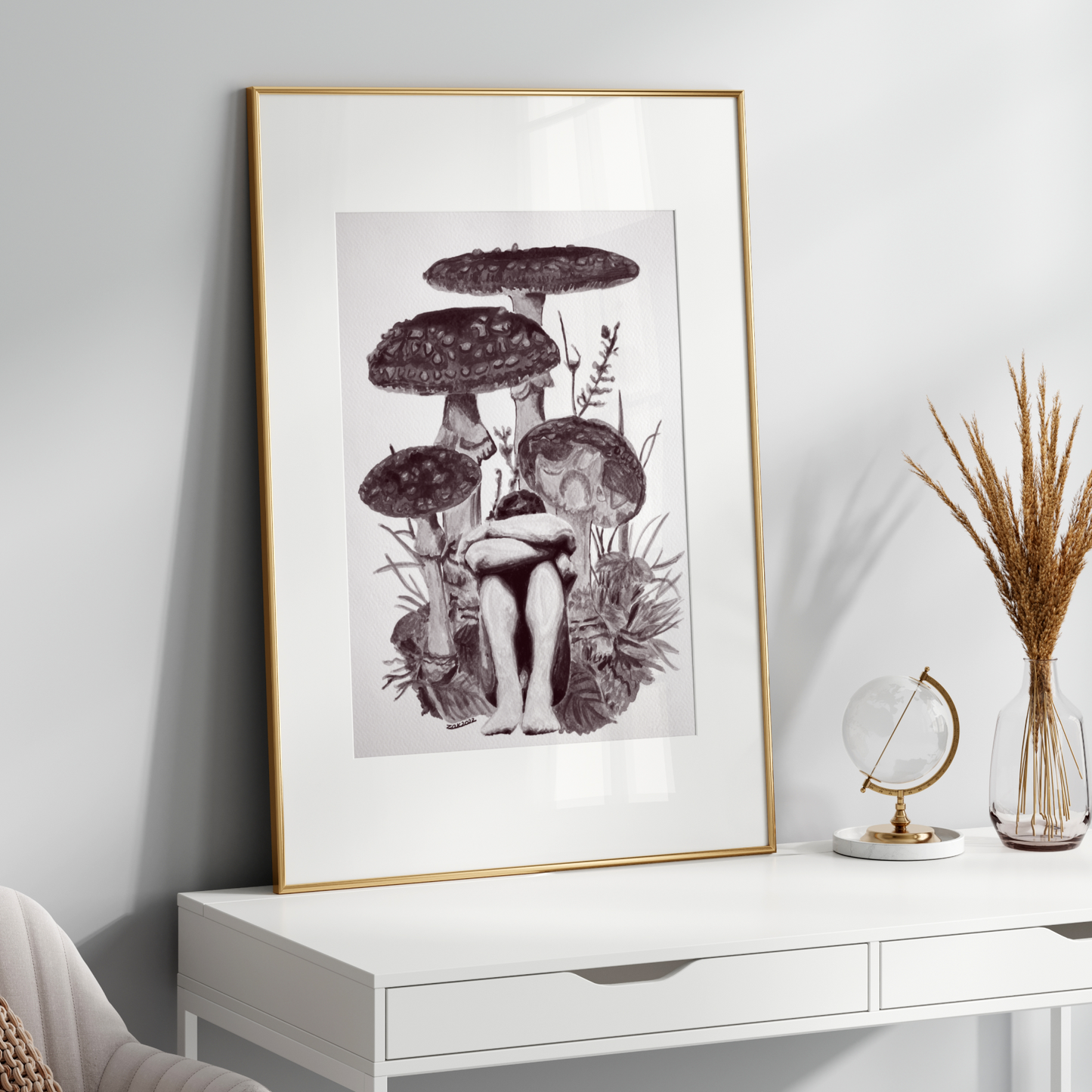 Framed artwork of mushrooms on a white wall above a white console table.